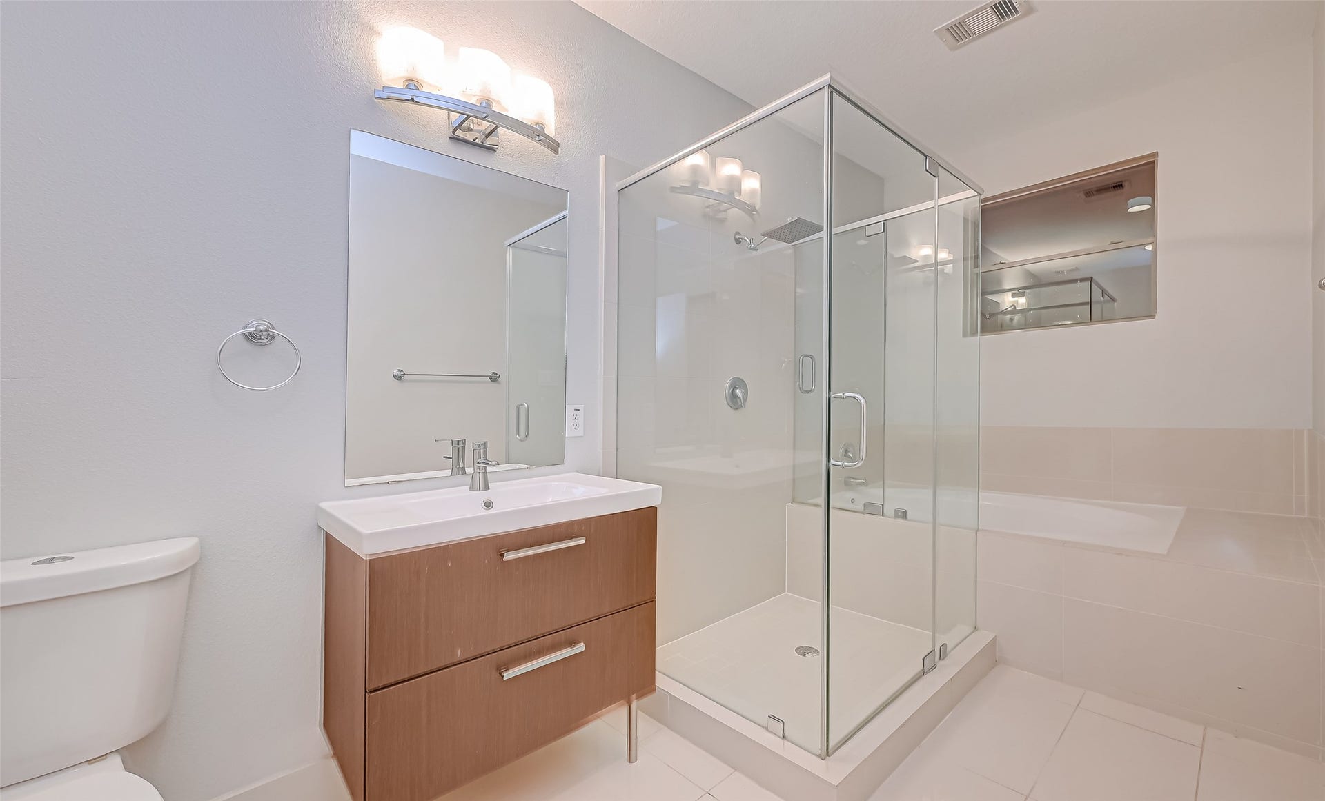 5111 Cornish Street, Houston, TX 77007 Modern bathroom featuring a sleek glass-enclosed shower, elegant vanity with ample storage, and a relaxing soaking tub.