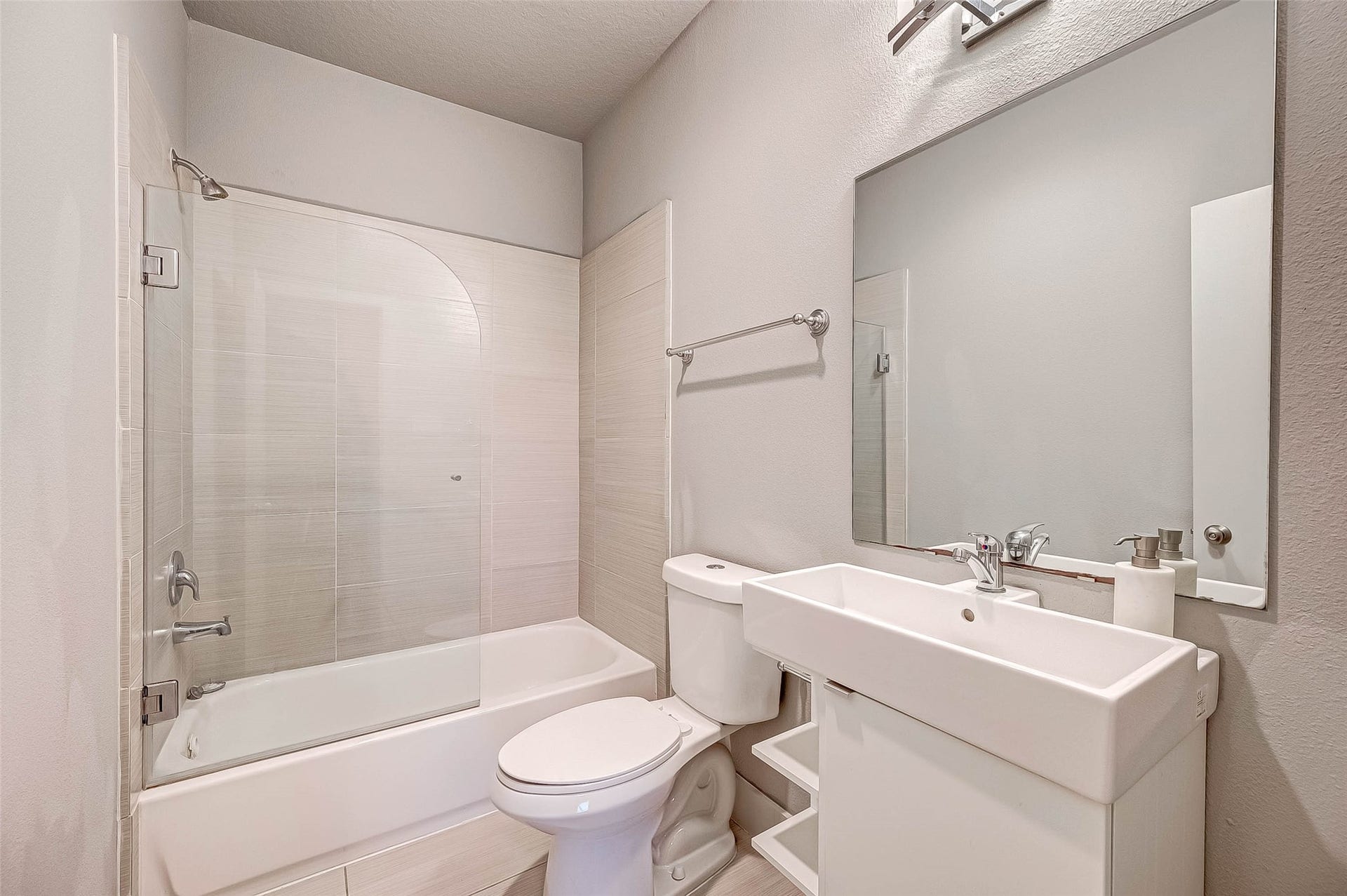 5111 Cornish Street, Houston, TX 77007 Modern bathroom featuring a sleek tub-shower combo, contemporary sink, and ample mirror space, all in a bright, neutral palette.