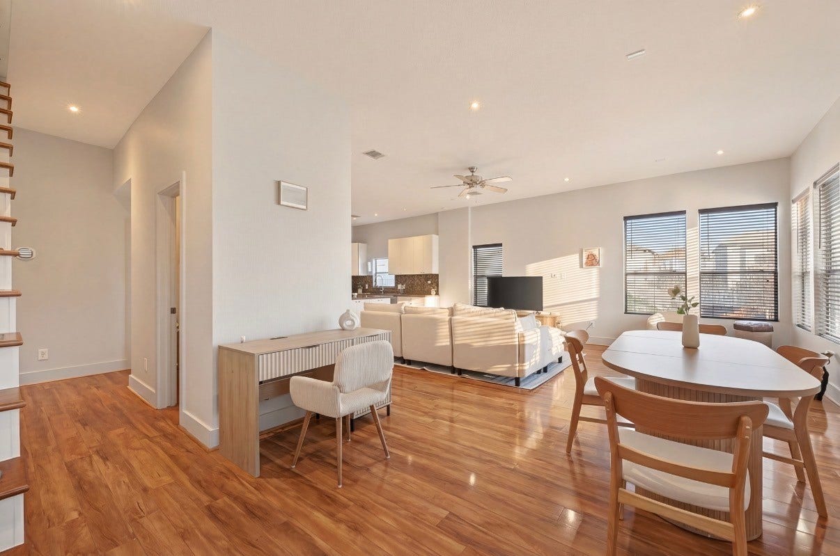 5111 Cornish Street, Houston, TX 77007 Bright and inviting open-concept living area featuring warm wood flooring, modern furnishings, ample natural light from large windows, and a cozy seating arrangement. Ideal for entertaining or relaxing.