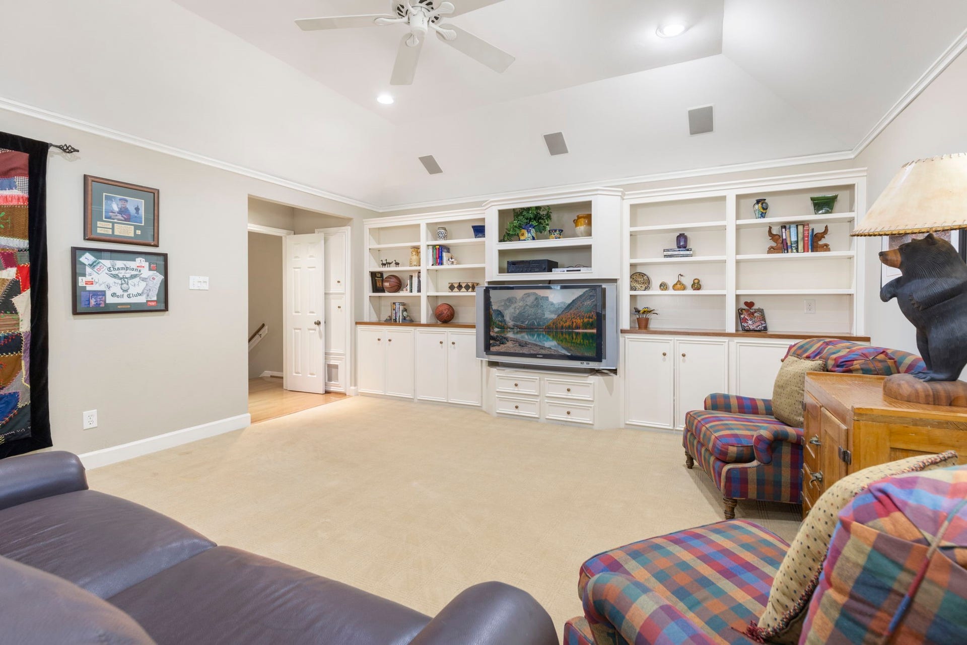 14018 Court Of Regents, Houston, TX 77069 Custom built ins combine display shelving, enclosed storage, and a central media niche to keep the game room organized.