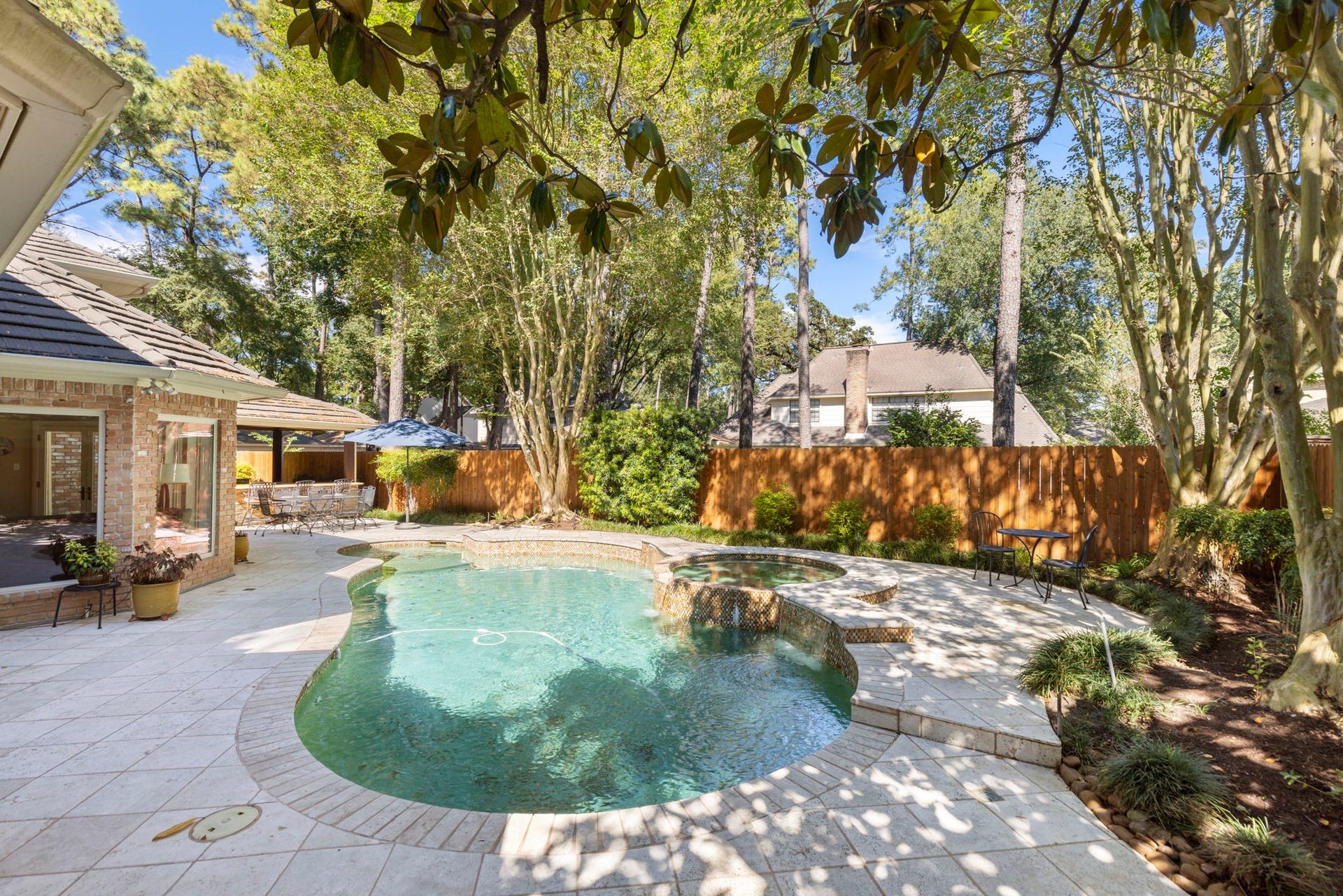 14018 Court Of Regents, Houston, TX 77069 Curving pool edges, generous decking, and mature landscaping create a backyard escape just steps from the house.