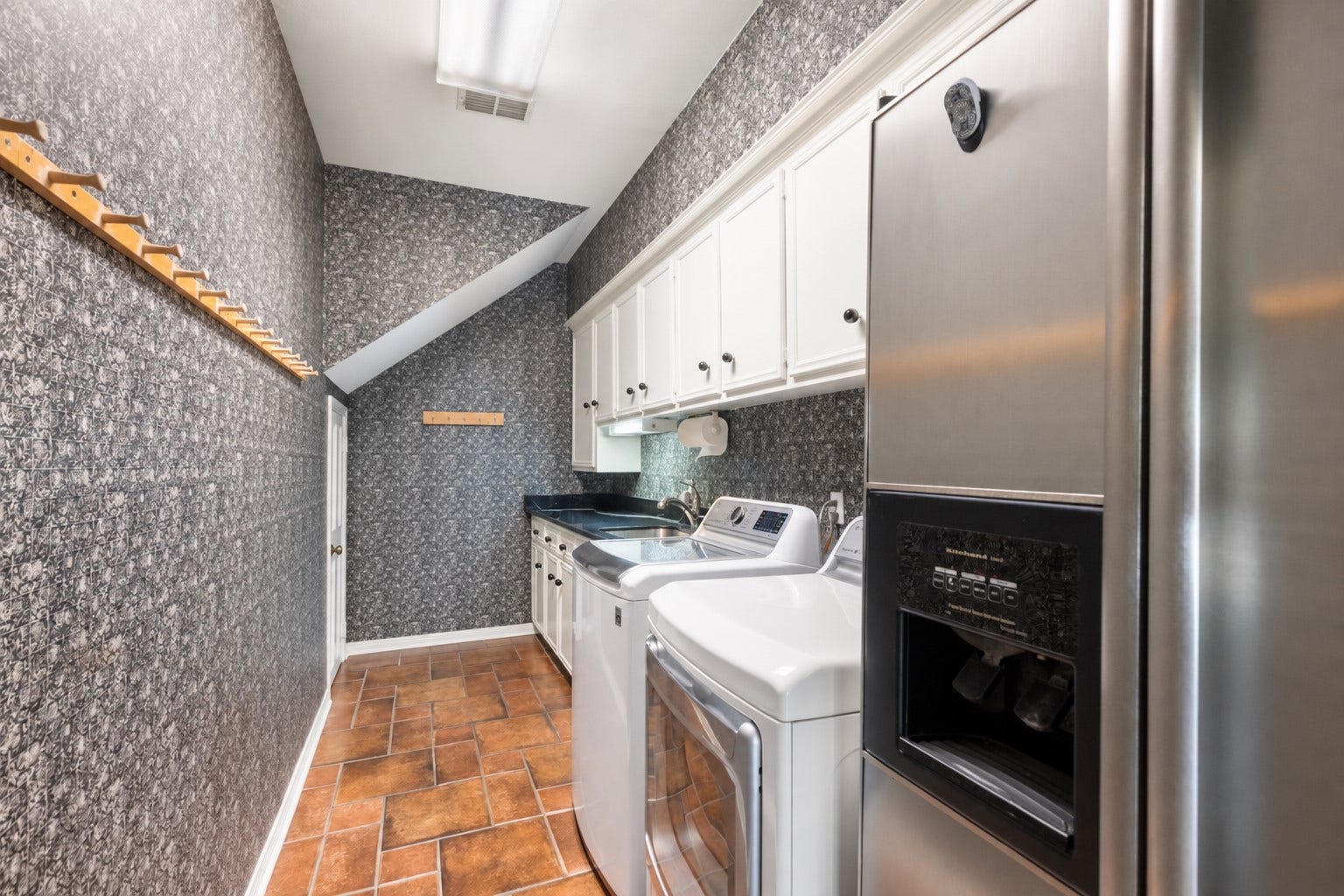 14018 Court Of Regents, Houston, TX 77069 Upper cabinets, a utility sink, and a hanging rod bring everyday convenience to the dedicated laundry room.