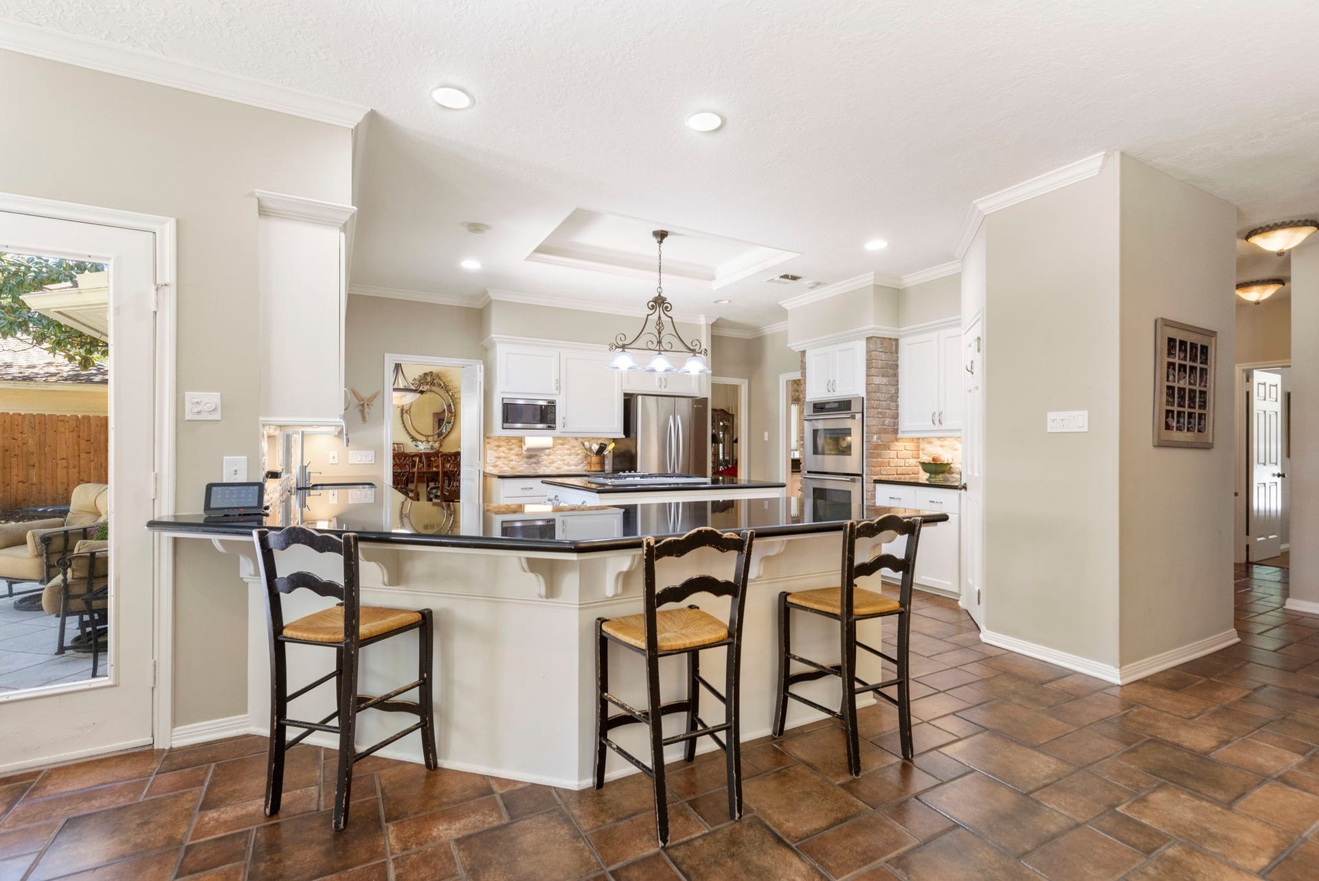 14018 Court Of Regents, Houston, TX 77069 Gather around the generous breakfast bar while enjoying an open connection between the kitchen and adjoining sunroom.