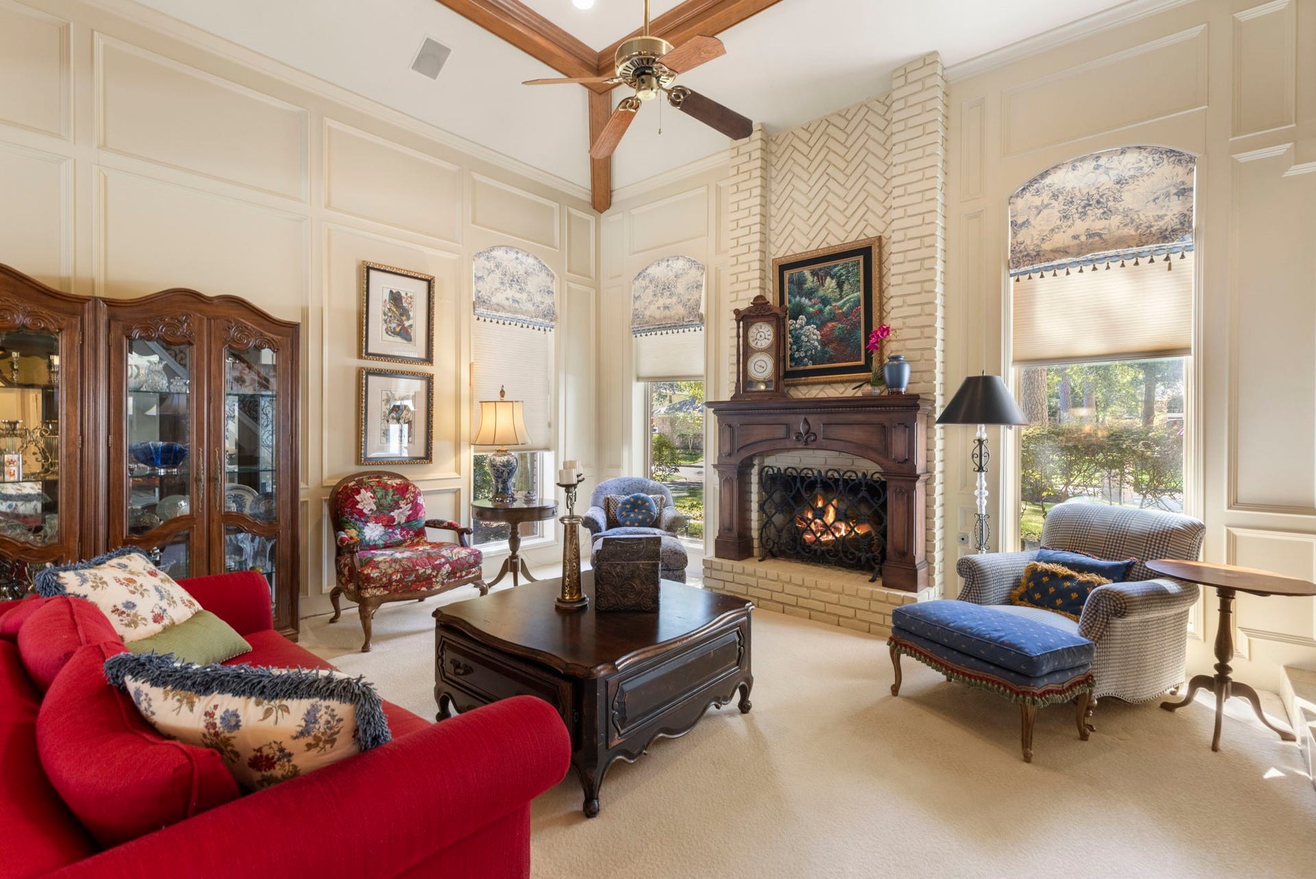 14018 Court Of Regents, Houston, TX 77069 Exposed ceiling beams and tall arched windows lend warmth and dimension to the beautifully proportioned living room.