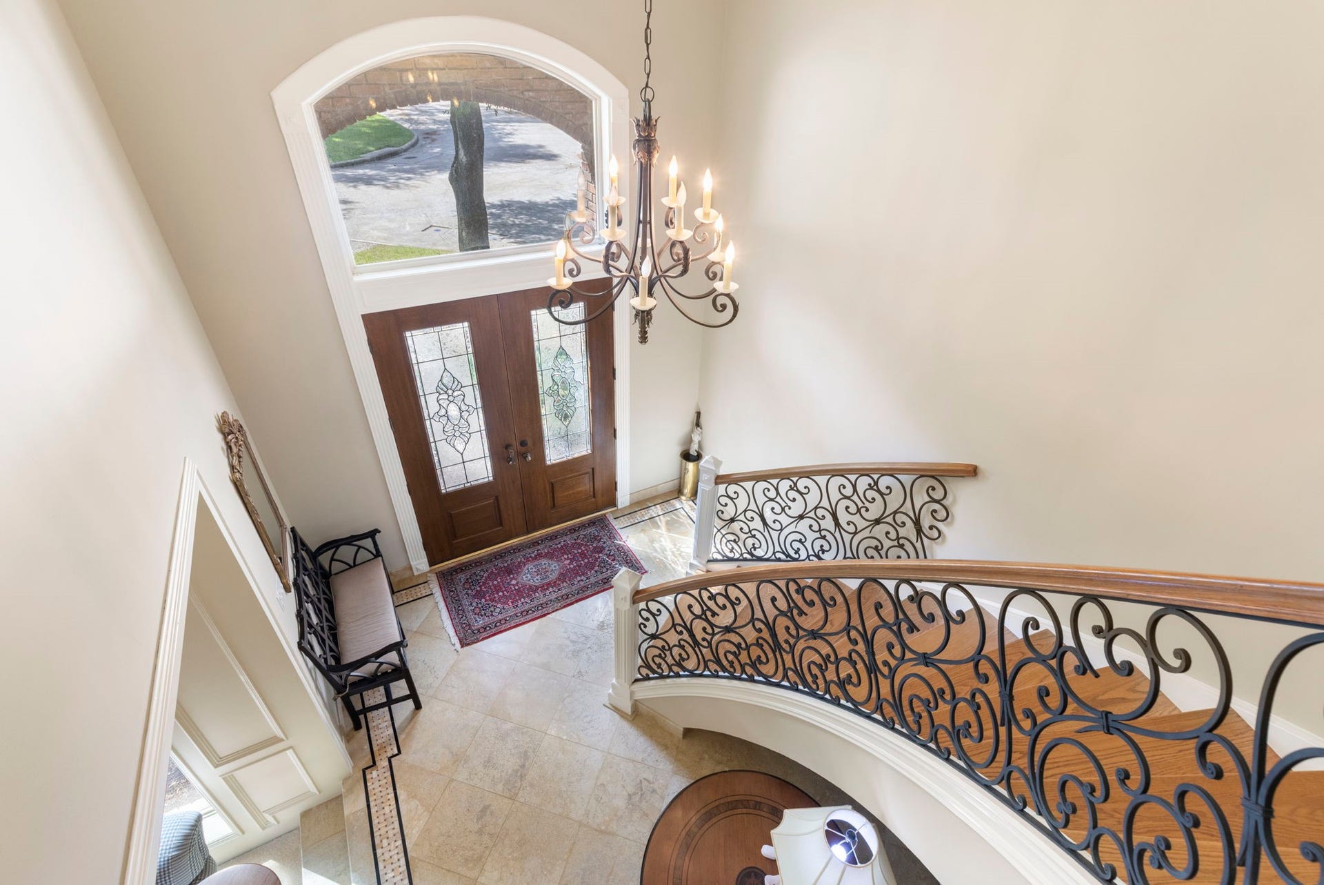 14018 Court Of Regents, Houston, TX 77069 Viewed from above, the dramatic foyer showcases graceful curves, intricate ironwork, and an arched window that welcomes natural light.