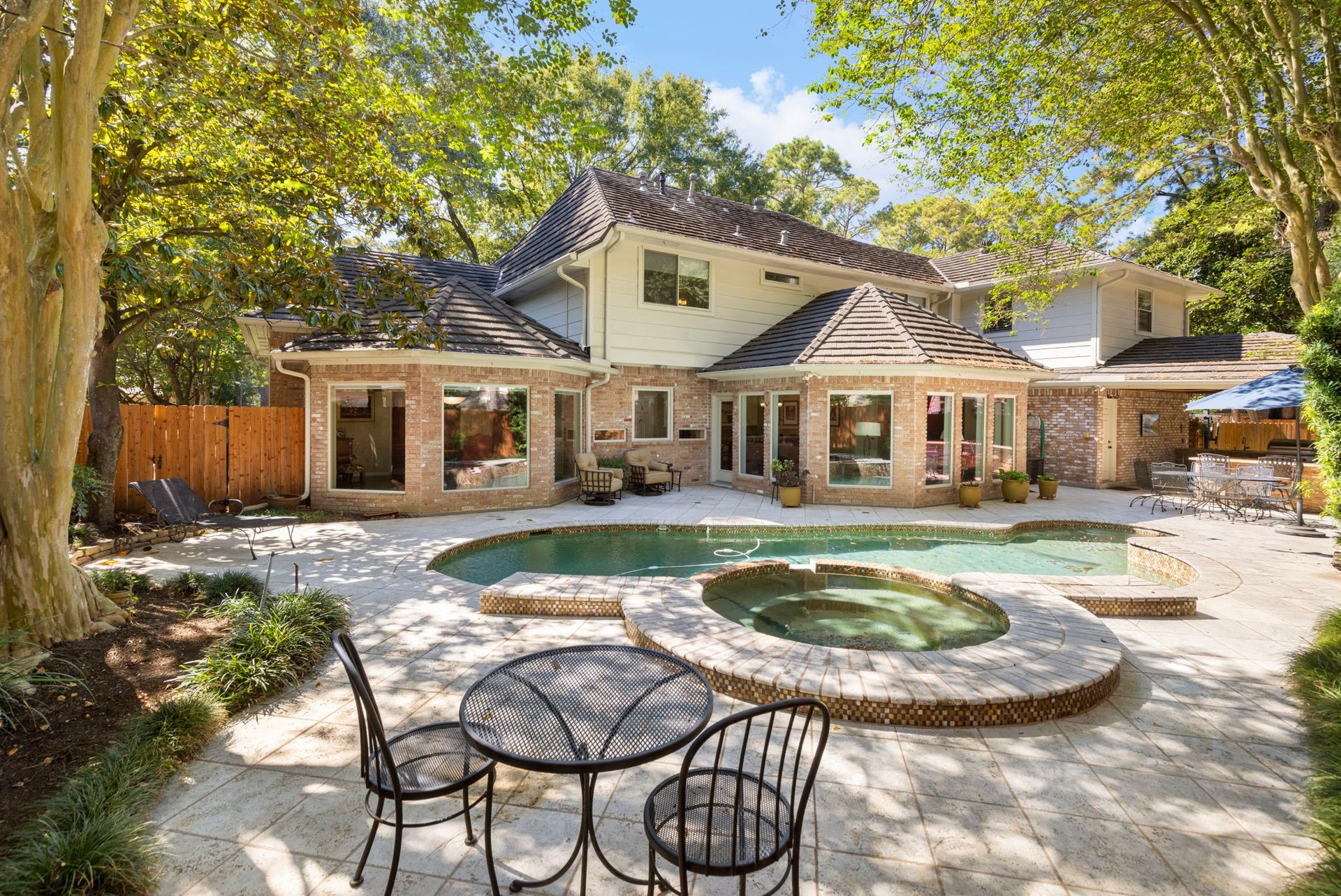 14018 Court Of Regents, Houston, TX 77069 A sparkling pool and raised spa anchor a secluded backyard designed for leisurely afternoons and memorable gatherings.