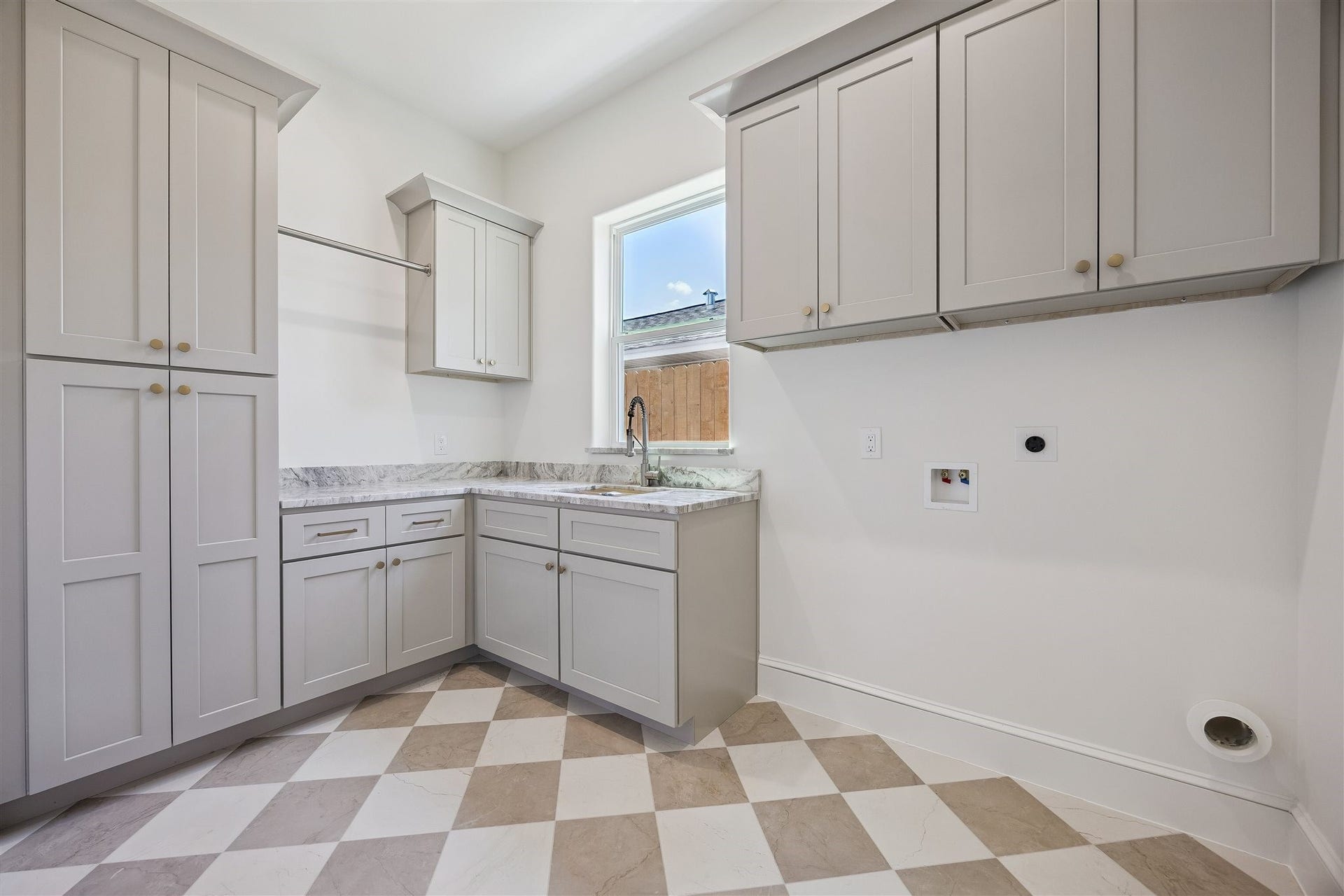 Laundry room with sink and abundant storage on first floor