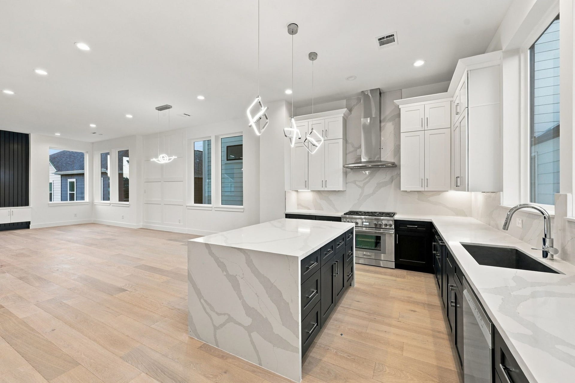1110 Peden Street, #A or B, Houston, TX 77006 Waterfall island, wide plank flooring, custom cabinets, 36" gas range, and quartz countertops/backsplash. This open concept kitchen and living area provide a higher-end design and feel compared to other nearby construction in Montrose.