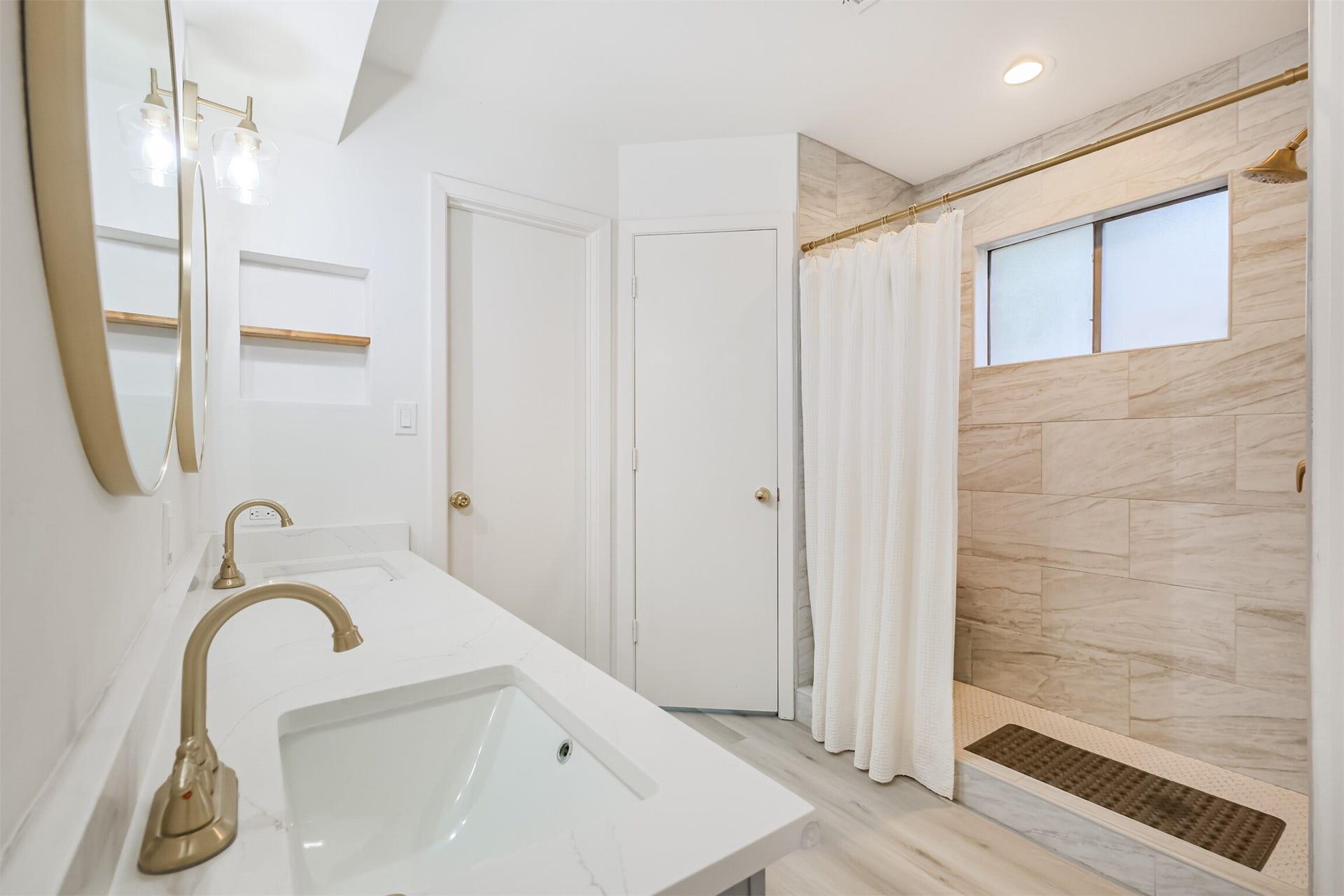 14211 Swiss Hill Drive, Houston, TX 77077 The primary bathroom has double sinks, quartz counters and a standing shower with tile surround.
