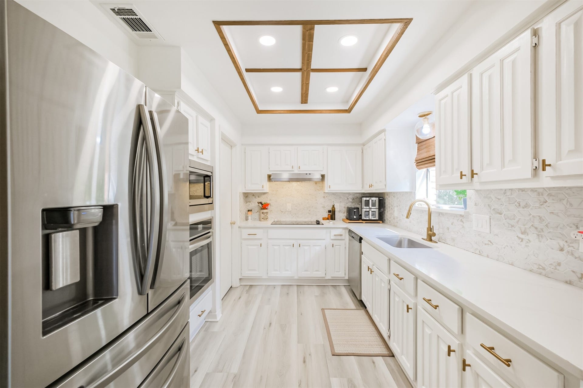14211 Swiss Hill Drive, Houston, TX 77077 There are quartz counters with tile backsplash, gold fixtures and stainless steel appliances in the kitchen.