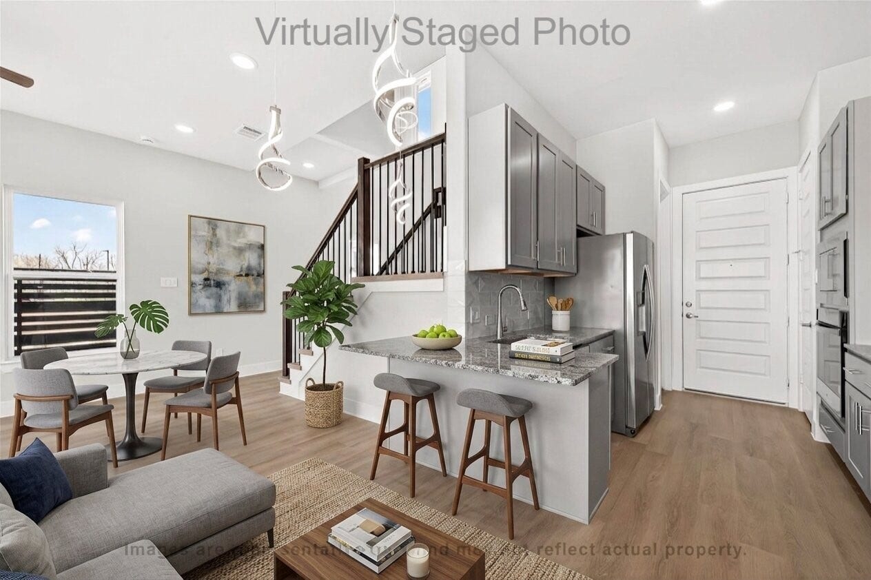 10719 Mason Rd, #32, Richmond, TX 77406 Virtual Staging - Open-concept living space featuring a modern kitchen with a breakfast bar, an adjacent dining area, and a wooden staircase
