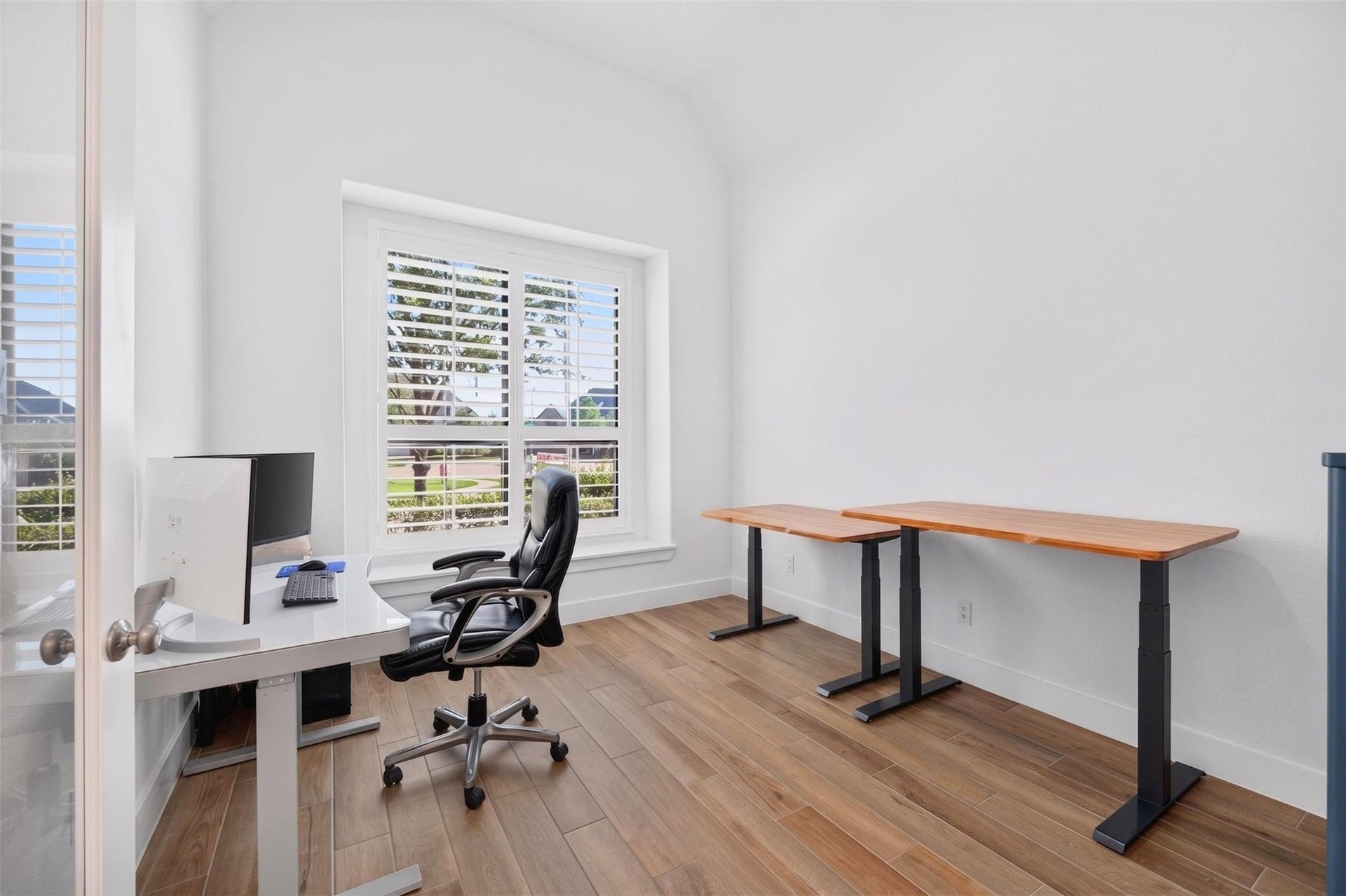 7014 San Bernard Trail, Katy, TX 77493 Bright home office with large window, sleek flooring, and ample desk space, perfect for productivity.