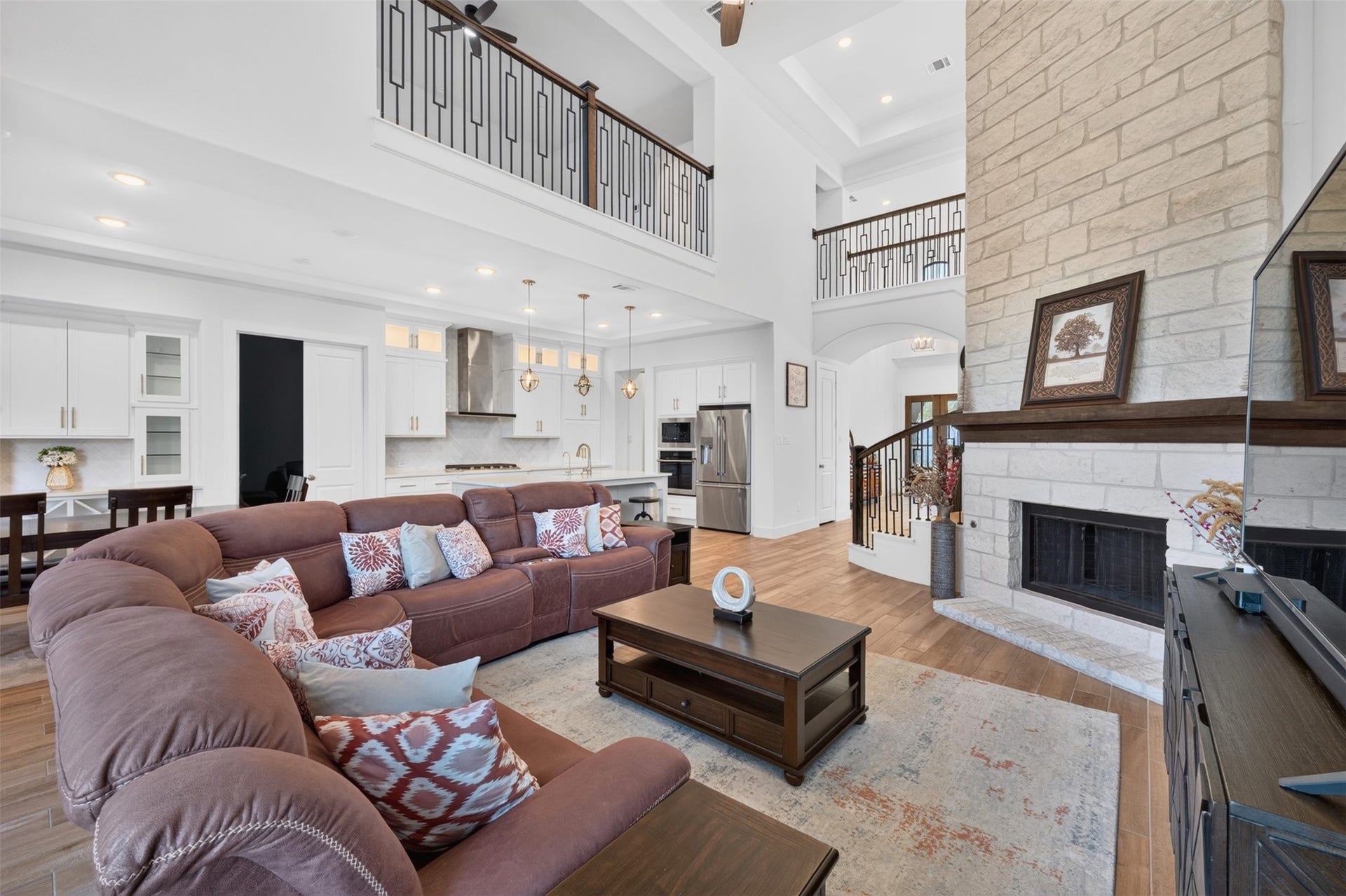 7014 San Bernard Trail, Katy, TX 77493 Elegant kitchen with sleek white cabinetry and a spacious island with seating. The open layout flows seamlessly into a cozy dining area, perfect for entertaining.