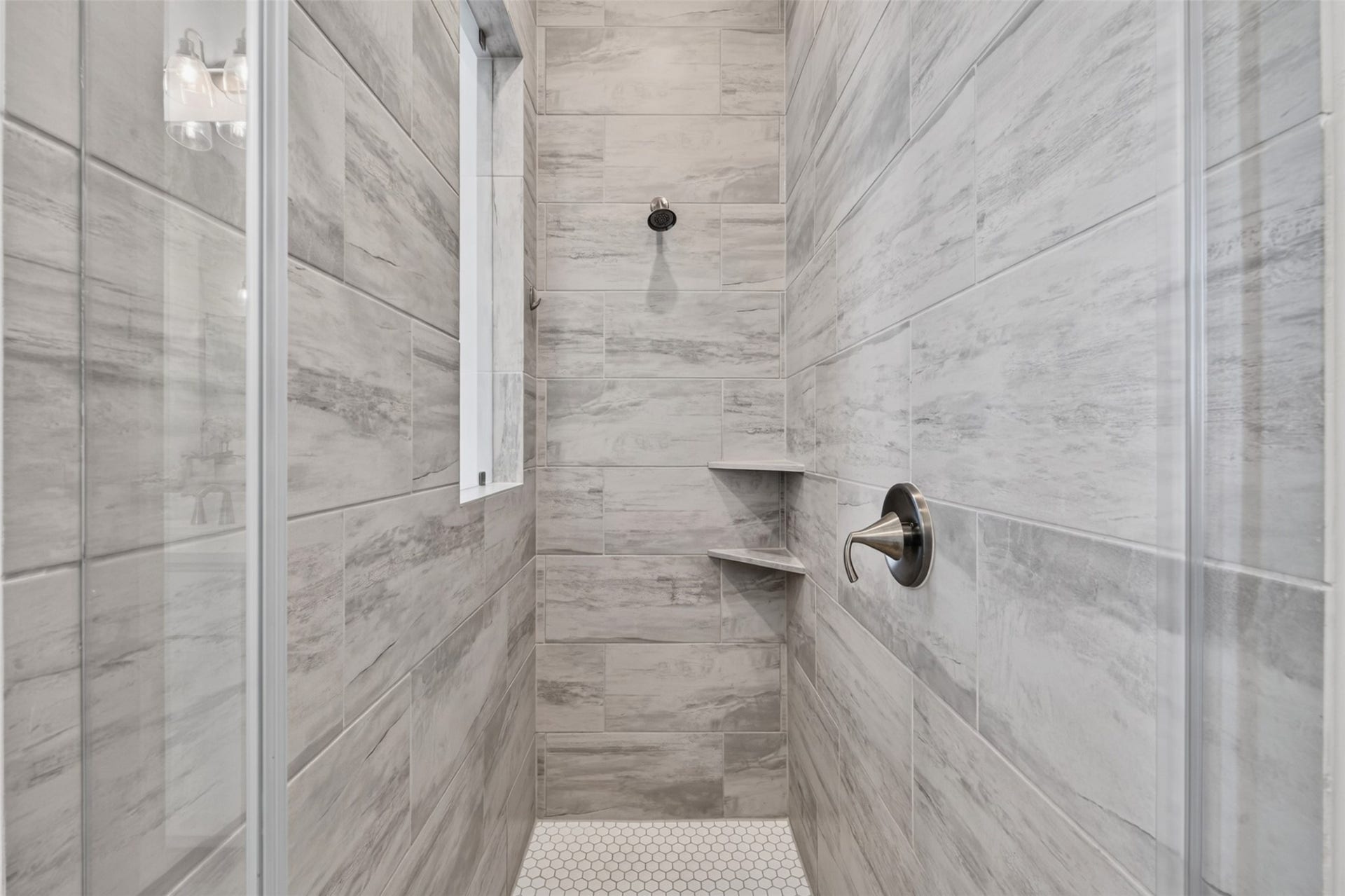 7014 San Bernard Trail, Katy, TX 77493 Sleek and modern shower with elegant gray tile and built-in shelving for convenience.