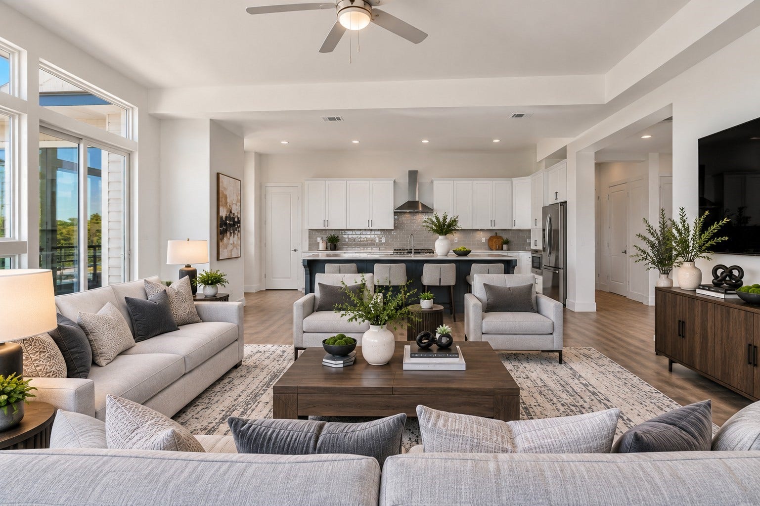 119 Kirby Road, #5303, Taylor Lake Village, TX 77586 Spacious open-concept living area with abundant natural light, featuring a modern kitchen with sleek white cabinetry, a cozy seating arrangement, and elegant decor. (Virtually staged room).
