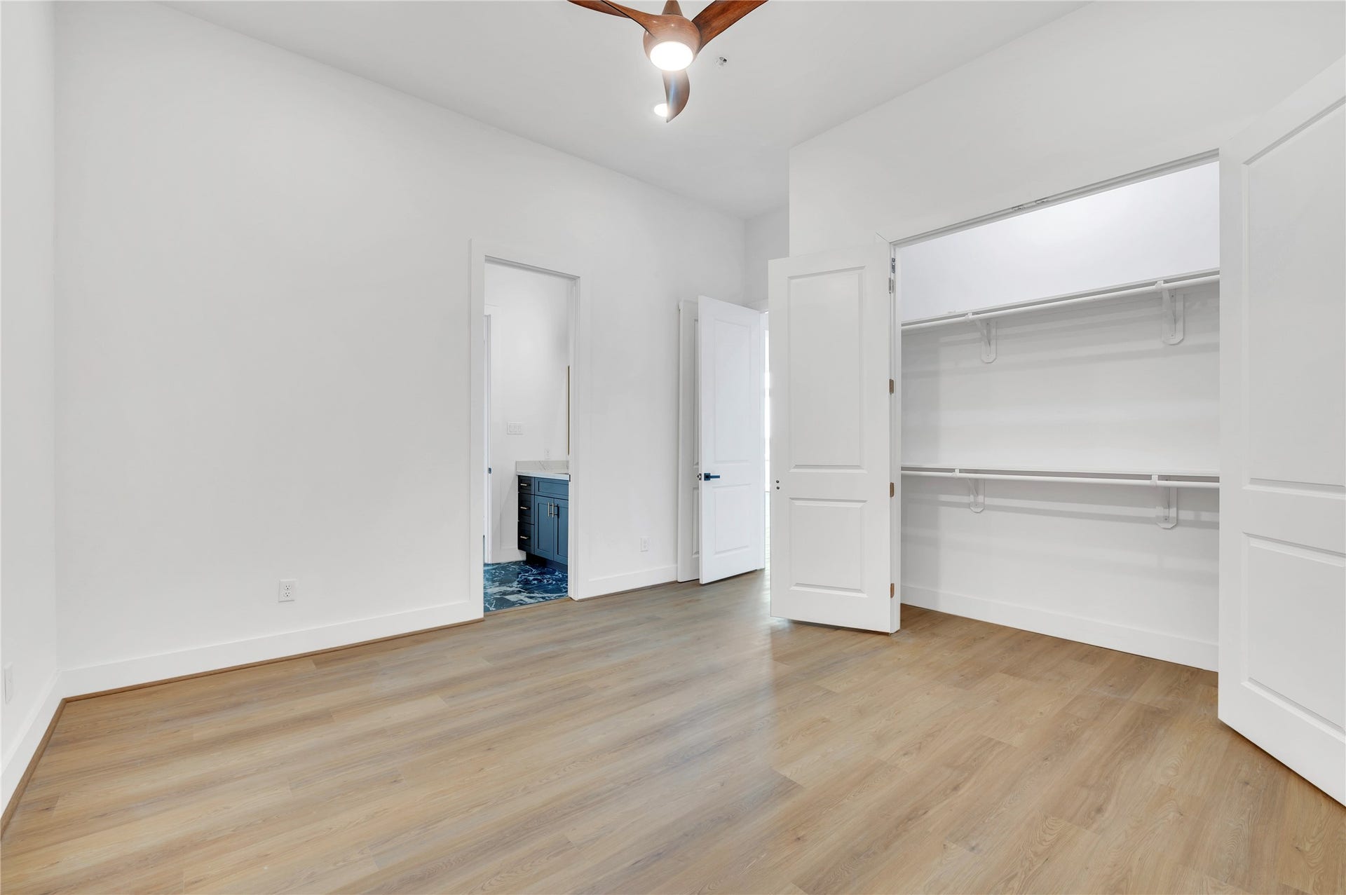 119 Kirby Road, #5303, Taylor Lake Village, TX 77586 Spacious bedroom with sleek hardwood floors, a modern ceiling fan, and a generous walk-in closet.