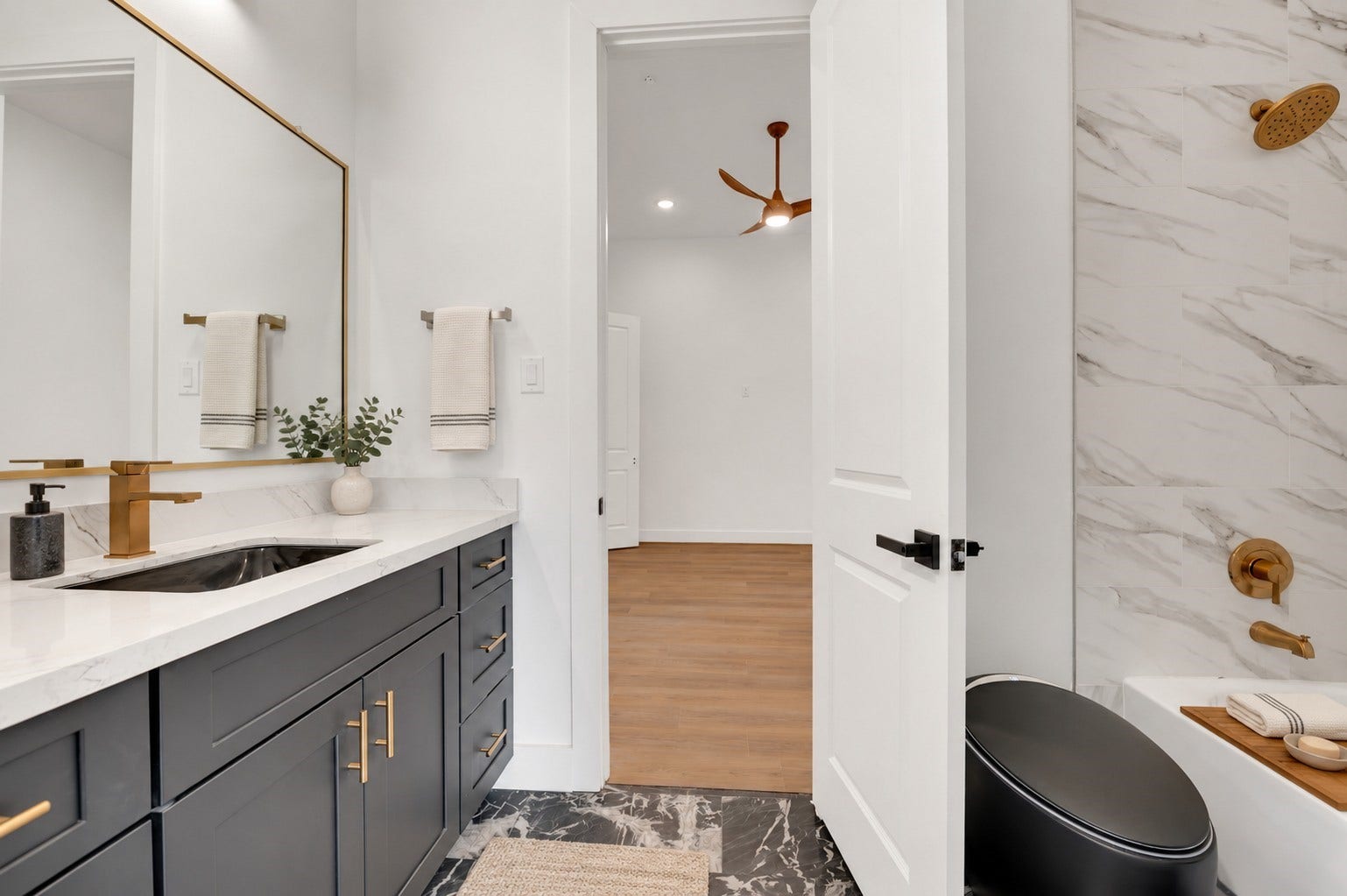 119 Kirby Road, #5303, Taylor Lake Village, TX 77586 Elegant bathroom featuring a modern vanity with gold fixtures, a sleek marble countertop, and a luxurious shower with marble tile accents.