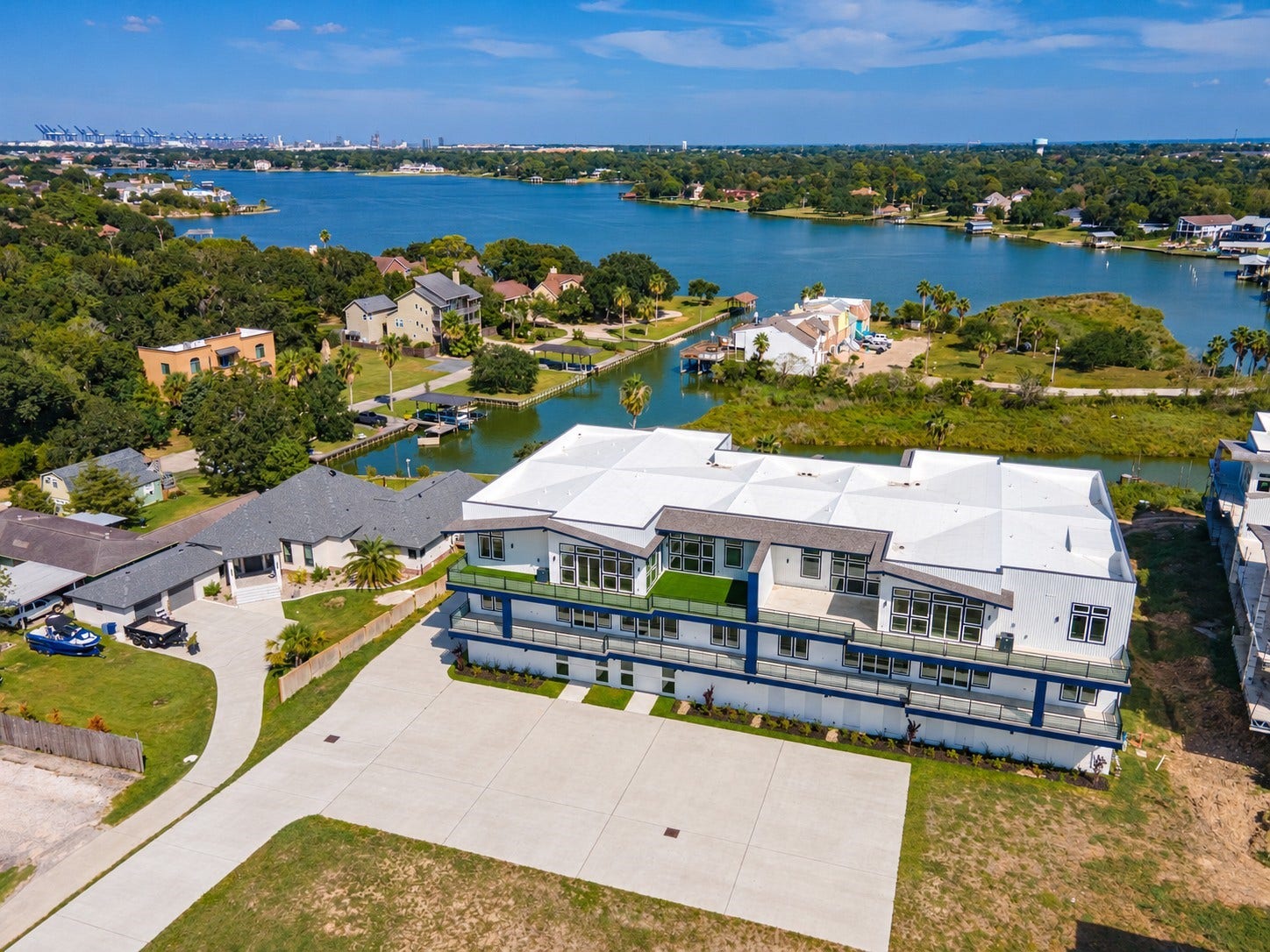 119 Kirby Road, #5303, Taylor Lake Village, TX 77586 Stunning waterfront property with expansive views, modern architecture, and a spacious driveway, offering serene lakeside living.