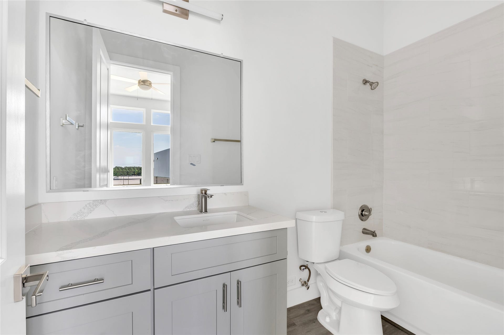 119 Kirby Road, #5303, Taylor Lake Village, TX 77586 Bright and modern bathroom featuring a sleek vanity with ample storage, a large mirror, and a combination bathtub and shower.