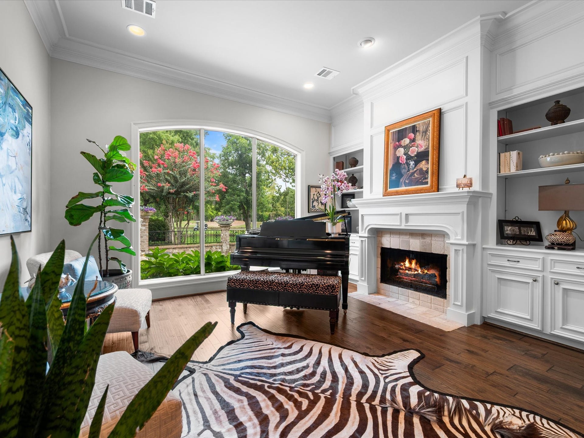 Soaring ceilings, elegant crown molding, classic built-ins, and a beautiful fireplace create a formal living room designed for both gracious entertaining and quiet moments at home.