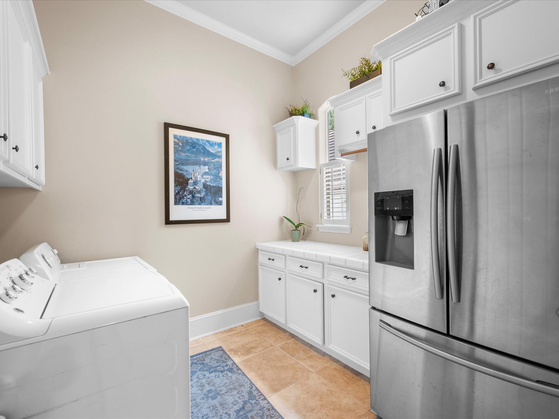 Designed with convenience in mind, the spacious utility room offers abundant cabinet storage and additional space for a secondary refrigerator or freezer.