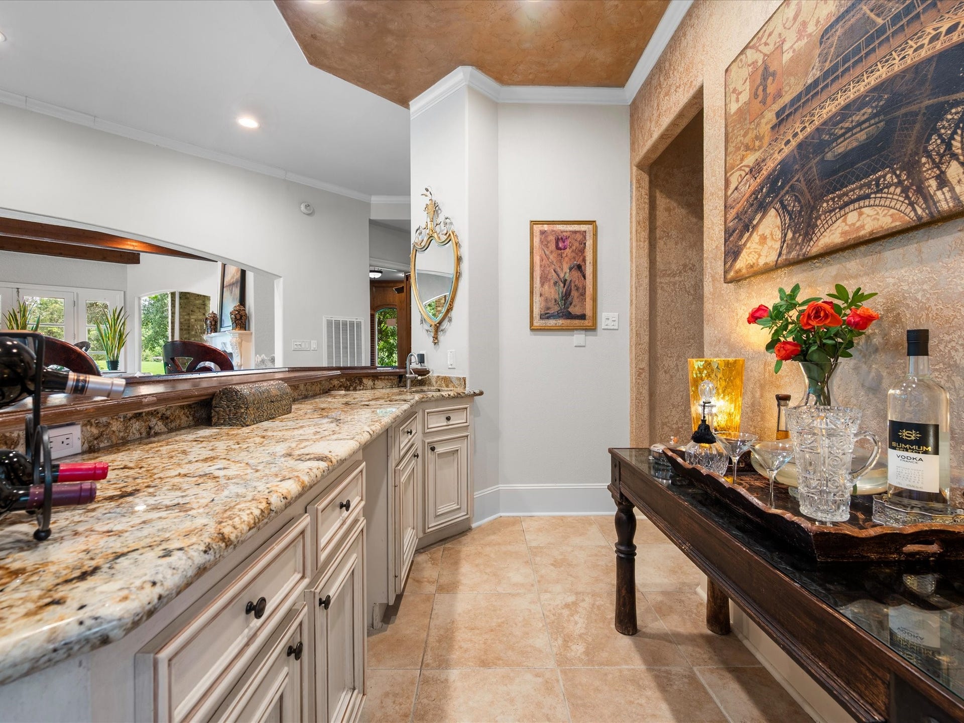 Granite countertops, beautiful cabinetry, and a conveniently placed sink elevate the wet bar, creating a stylish and functional space for entertaining.