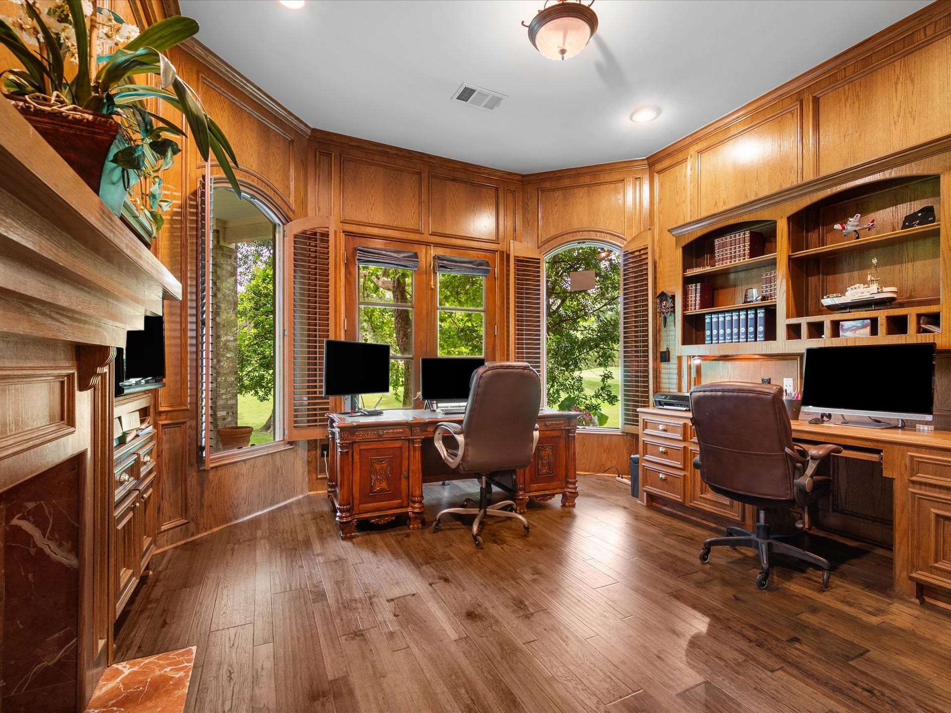 Rich wood tones, custom built-ins, and sweeping fairway views create an exquisite study where working from home feels both inspiring and serene.