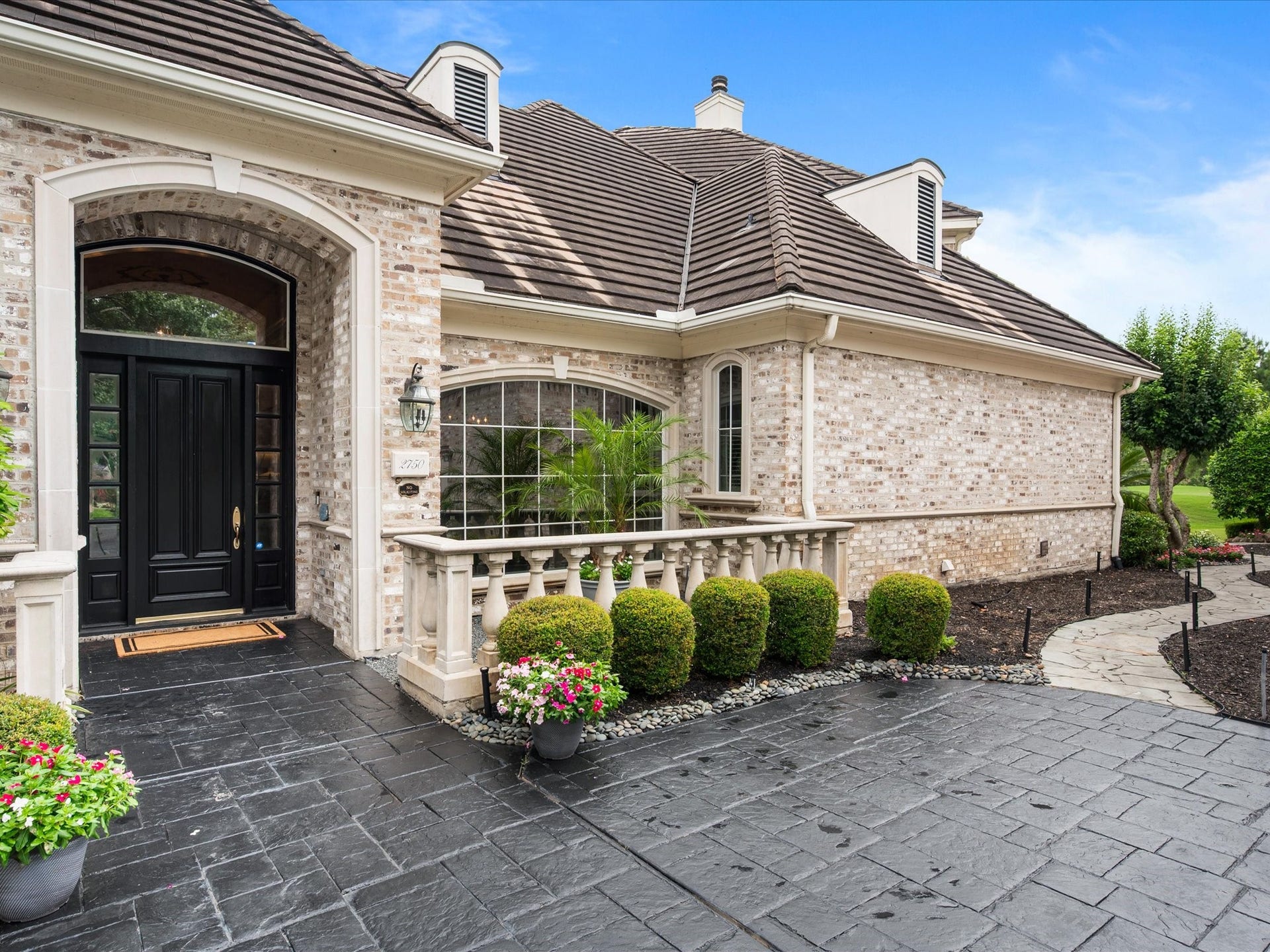 Charming garden spaces and thoughtfully curated landscaping surround the home, while the enduring concrete tile roof enhances both beauty and lasting quality.