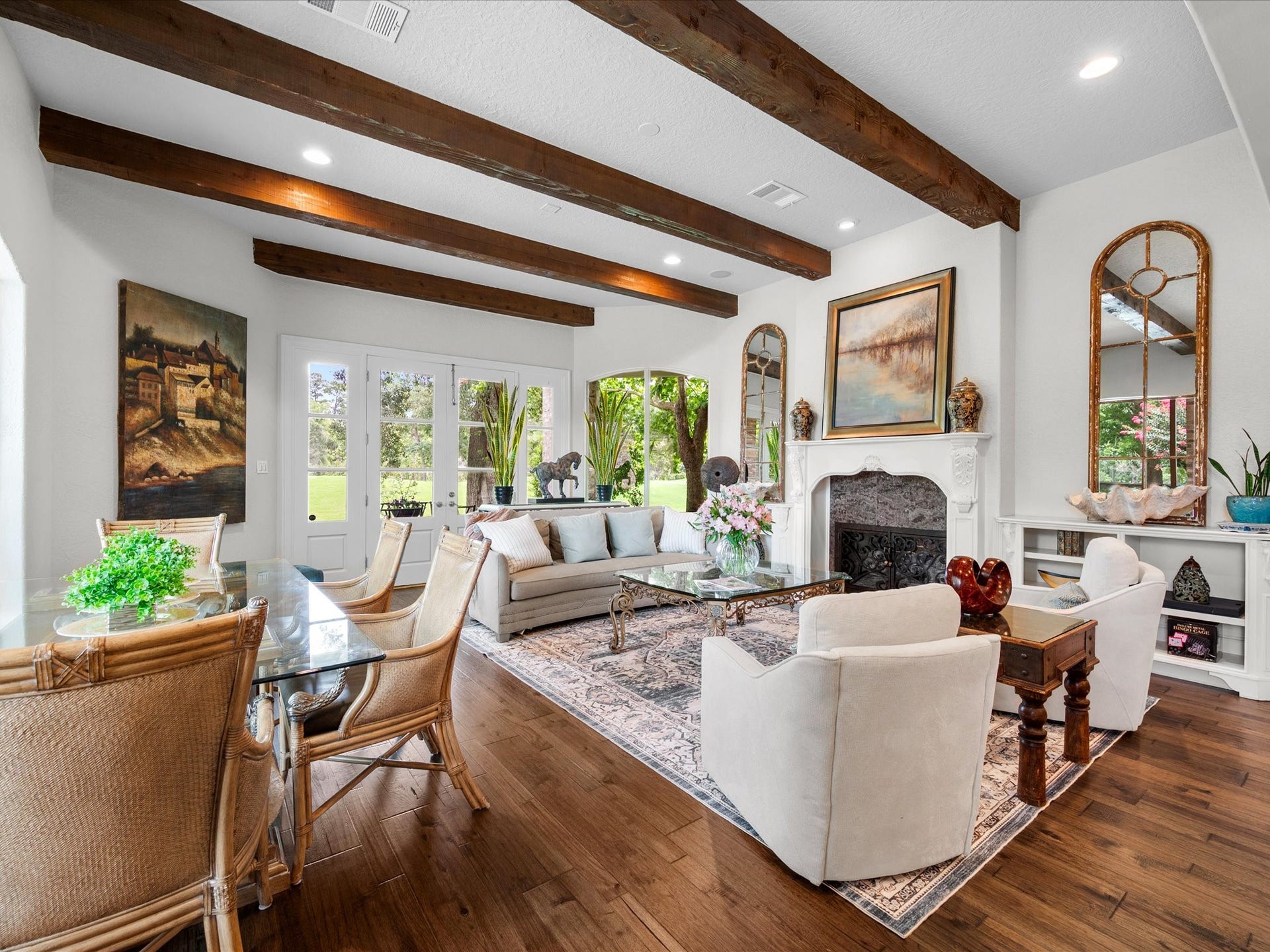 A striking fireplace anchors this light-filled space, where abundant windows and recently installed engineered hardwood floors (2025) enhance the home's timeless elegance.