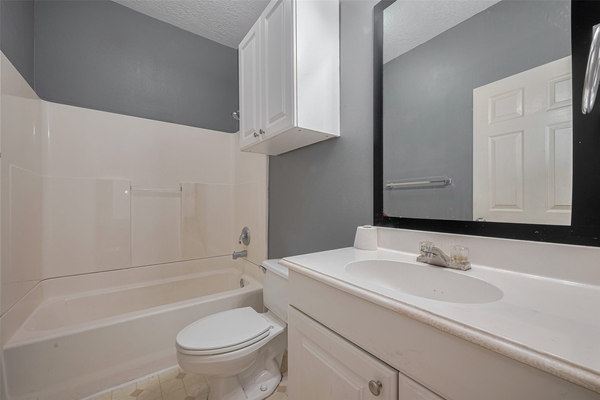 11214 Palmsprings Drive, Houston, TX 77034 Upstairs hall bathroom includes a tub-and-shower combination, vanity storage, and a wall cabinet.