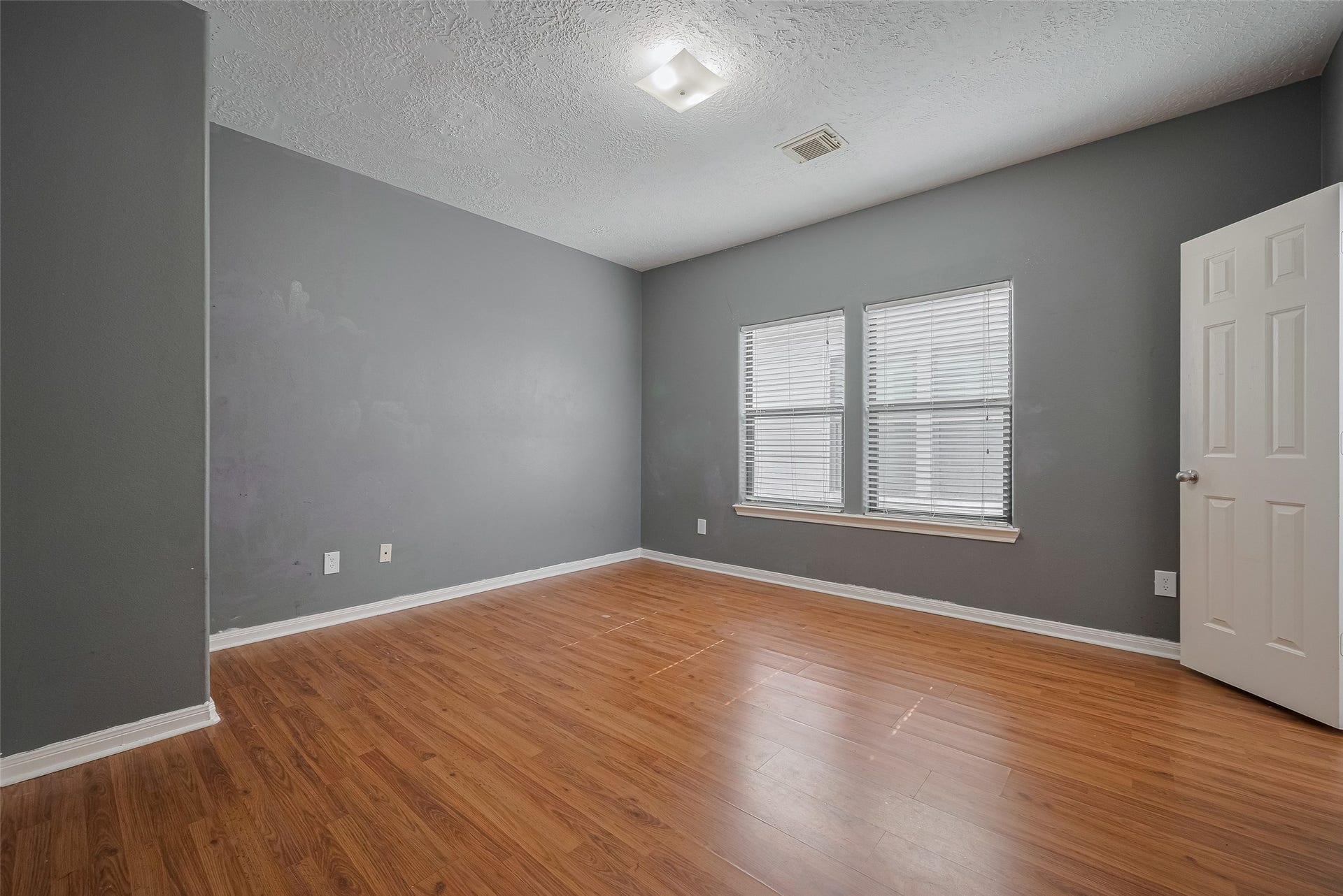 11214 Palmsprings Drive, Houston, TX 77034 Secondary bedroom features paired windows, neutral wall colors, and wood-look flooring.