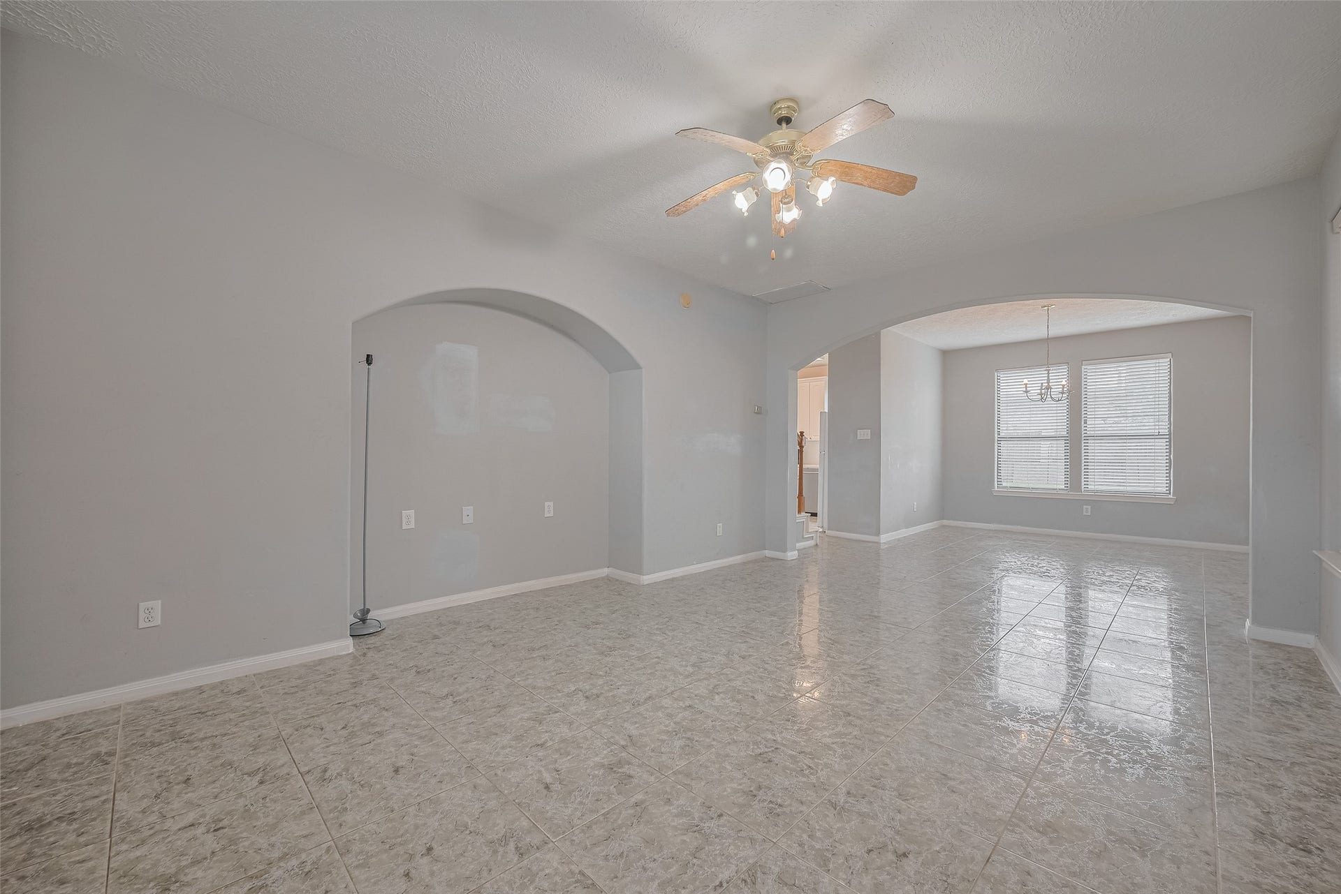11214 Palmsprings Drive, Houston, TX 77034 Living area features tile flooring, a ceiling fan, a decorative arched niche, and a wide opening to the adjoining dining area.