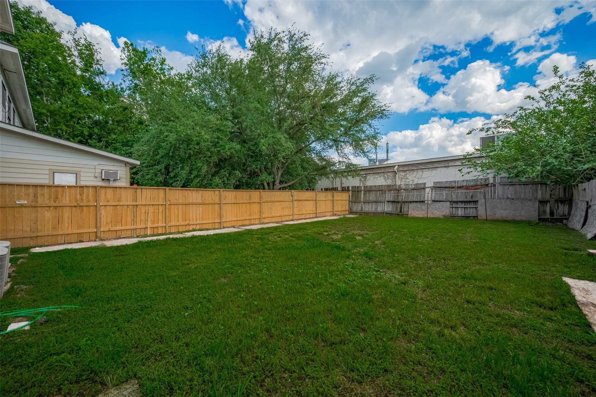 11214 Palmsprings Drive, Houston, TX 77034 Alternate backyard view highlights the open outdoor space and trees along the fence line.