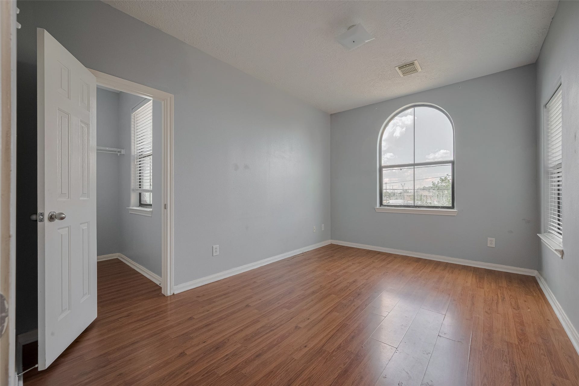 11214 Palmsprings Drive, Houston, TX 77034 Another secondary bedroom features an arched window, an additional side window, and wood-look flooring.