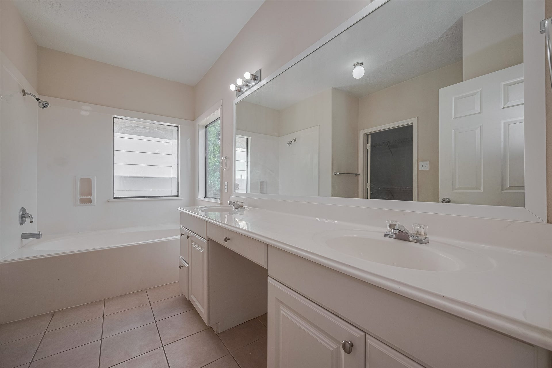 11214 Palmsprings Drive, Houston, TX 77034 Primary bathroom features a long vanity with two sinks, a seated vanity area, and a large mirror.
