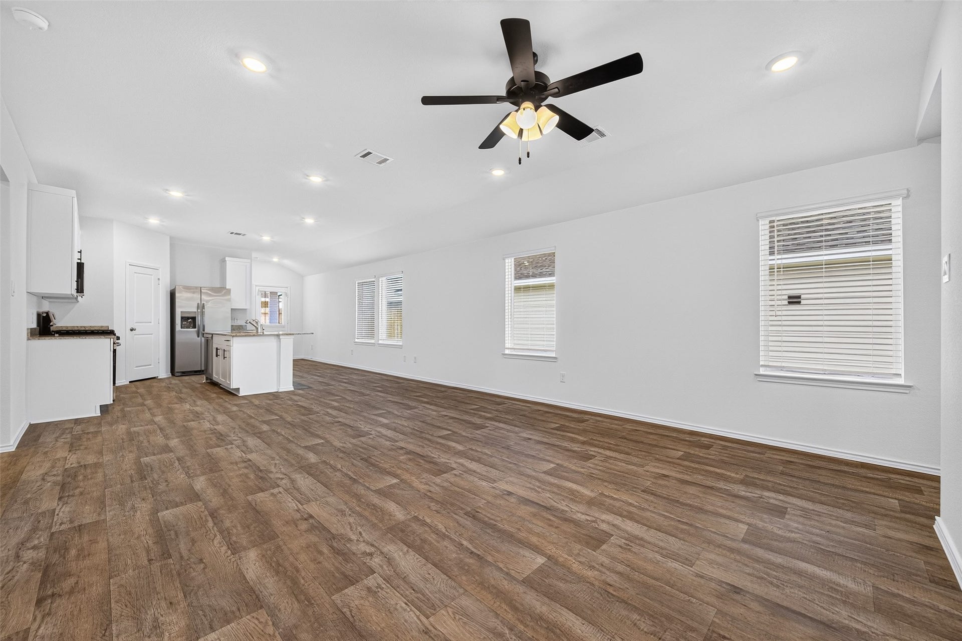 31214 Carmelas Landing Drive, Fulshear, TX 77441 View of the family room with fan and kitchen in the distance