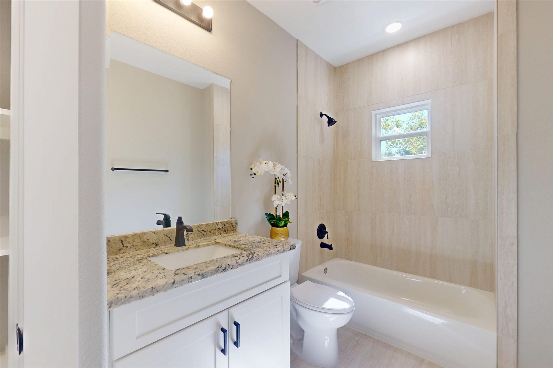 8709 Wheatley Street, Houston, TX 77088 Unit A: Primary bathroom featuring a tub and shower combination with modern finishes.
