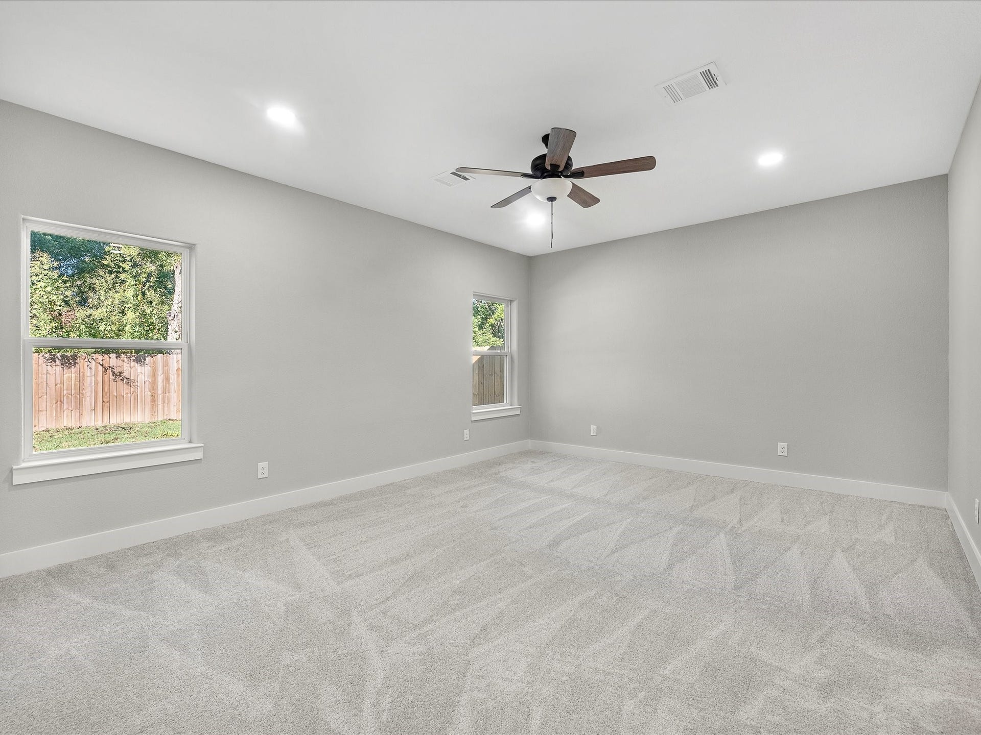 8709 Wheatley Street, Houston, TX 77088 Unit B: Spacious primary bedroom with ceiling fan and natural light.