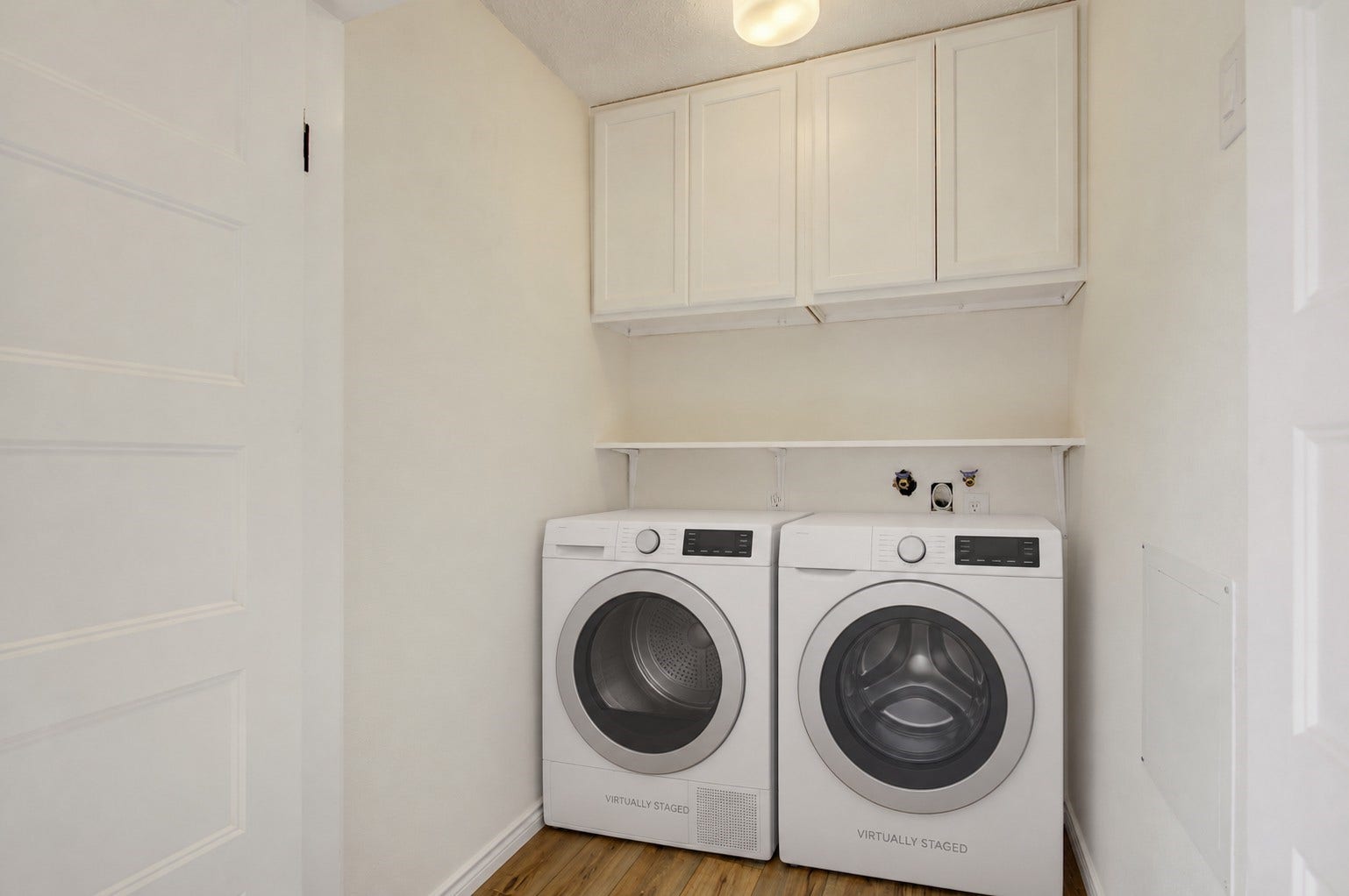 A view of the laundry room with storage cabinets *virtually staged, washer/dryer not included*