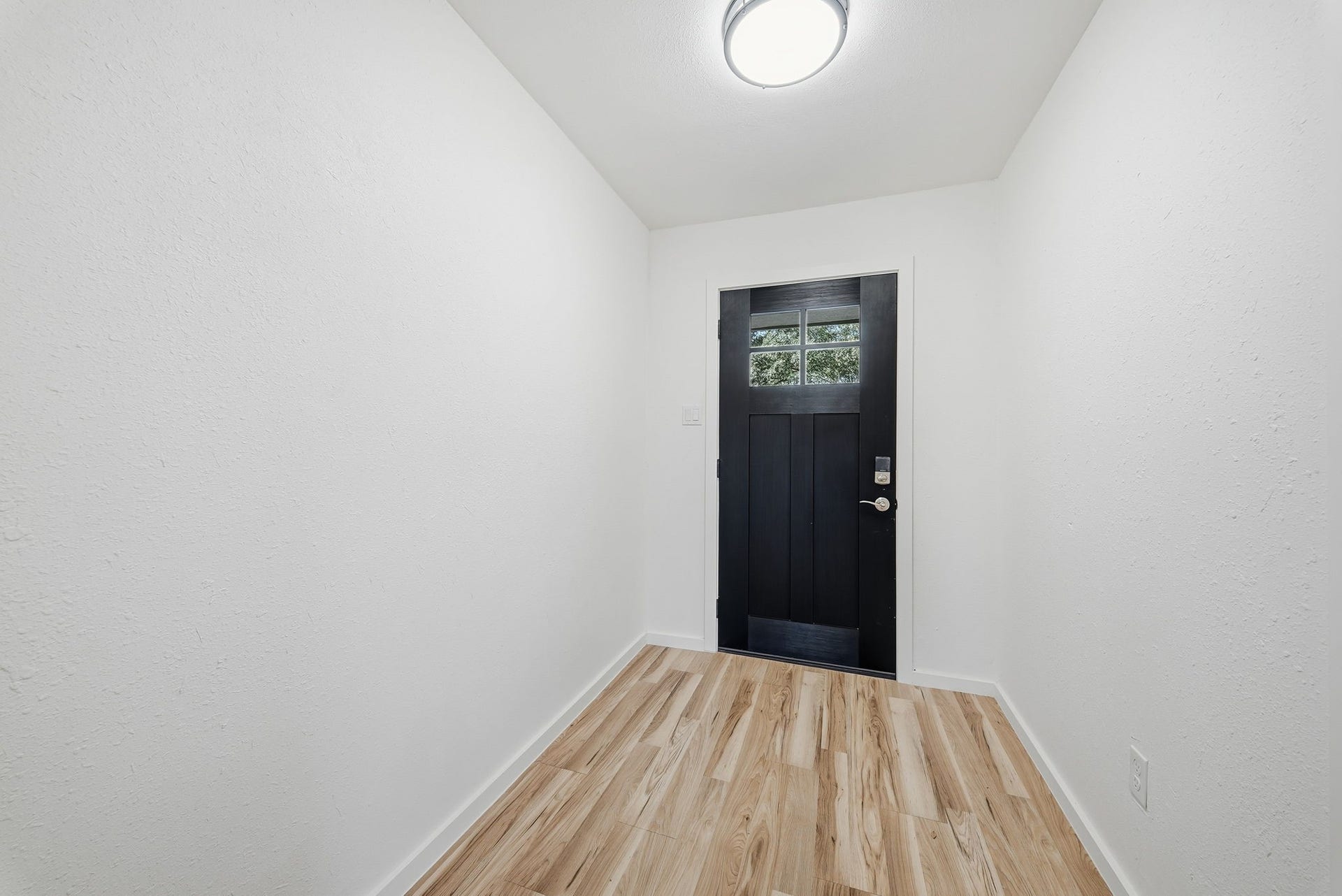 3027 Longhorn Drive, Rosenberg, TX 77471 Foyer entry with a modern black front door and a keypad lock.