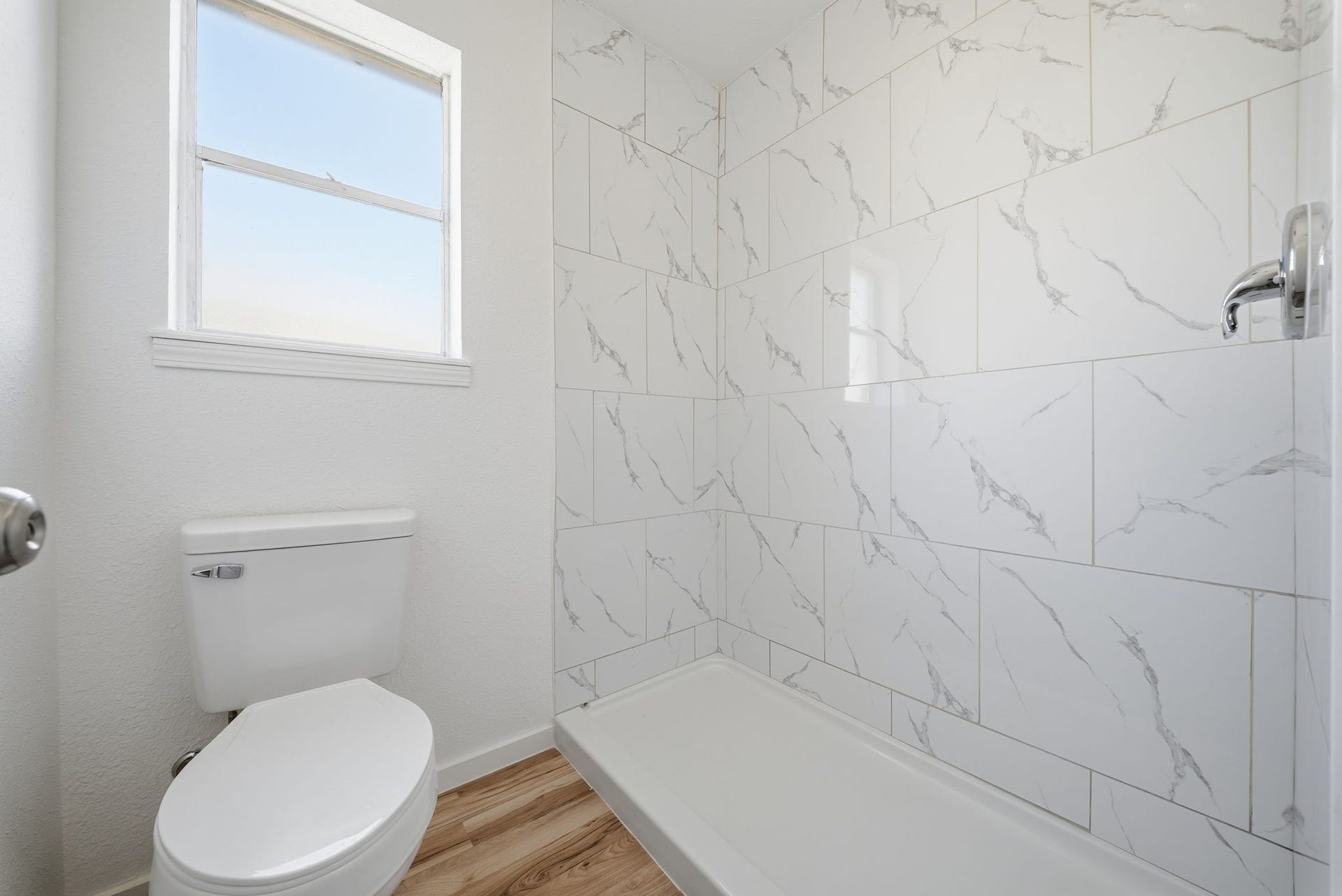 3027 Longhorn Drive, Rosenberg, TX 77471 Primary walk-in shower in large marble-look tile, with a window for natural light.