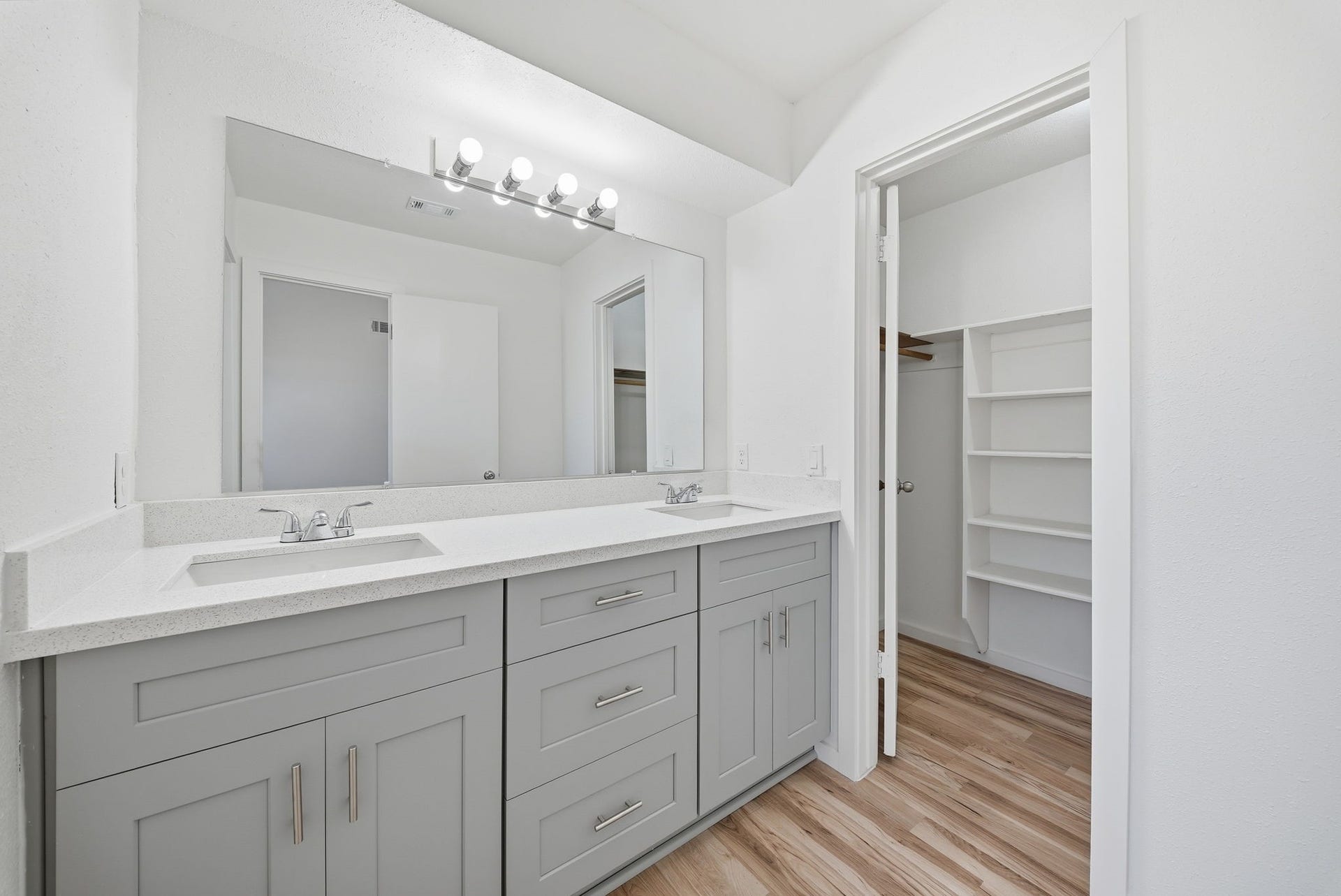 3027 Longhorn Drive, Rosenberg, TX 77471 Primary bath double-sink vanity beside a walk-in closet with built-in shelves.