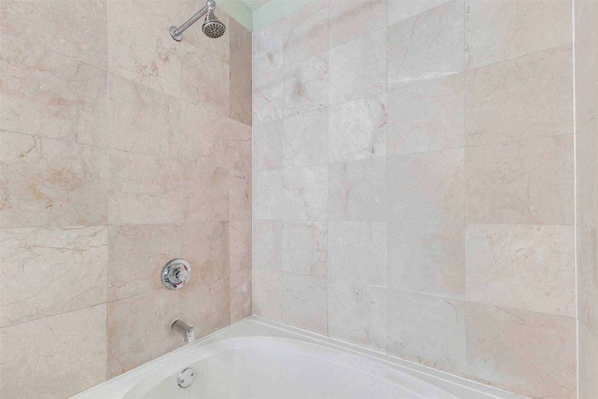 3505 Sage Road, #1104, Houston, TX 77056 The bathroom includes a full tub and shower combination surrounded by large tile walls that provide a clean, polished appearance. The neutral tile tones create a timeless look while also offering easy maintenance and durability. The spacious design allows for both relaxing baths and convenient showers, making it suitable for a variety of daily routines. With simple modern fixtures and bright lighting, this bathing space feels fresh and comfortable.