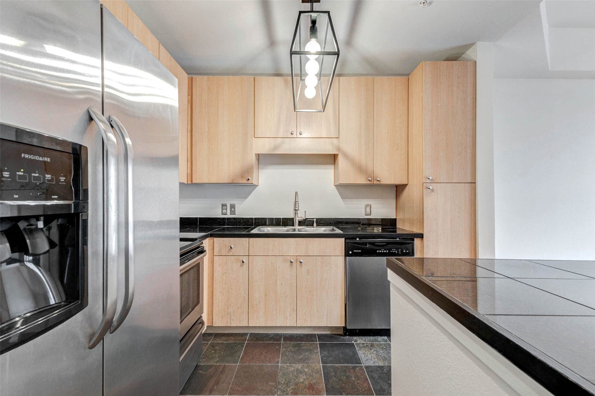3505 Sage Road, #1104, Houston, TX 77056 Designed with both style and efficiency in mind, the kitchen offers a practical layout with easy access to all appliances and work surfaces. Stainless steel appliances, including range, microwave, and refrigerator, provide a modern touch while the generous cabinetry ensures ample storage. The double sink and extended counter space make food prep and cleanup simple, while the tile flooring adds durability and easy maintenance to this busy hub of the home.