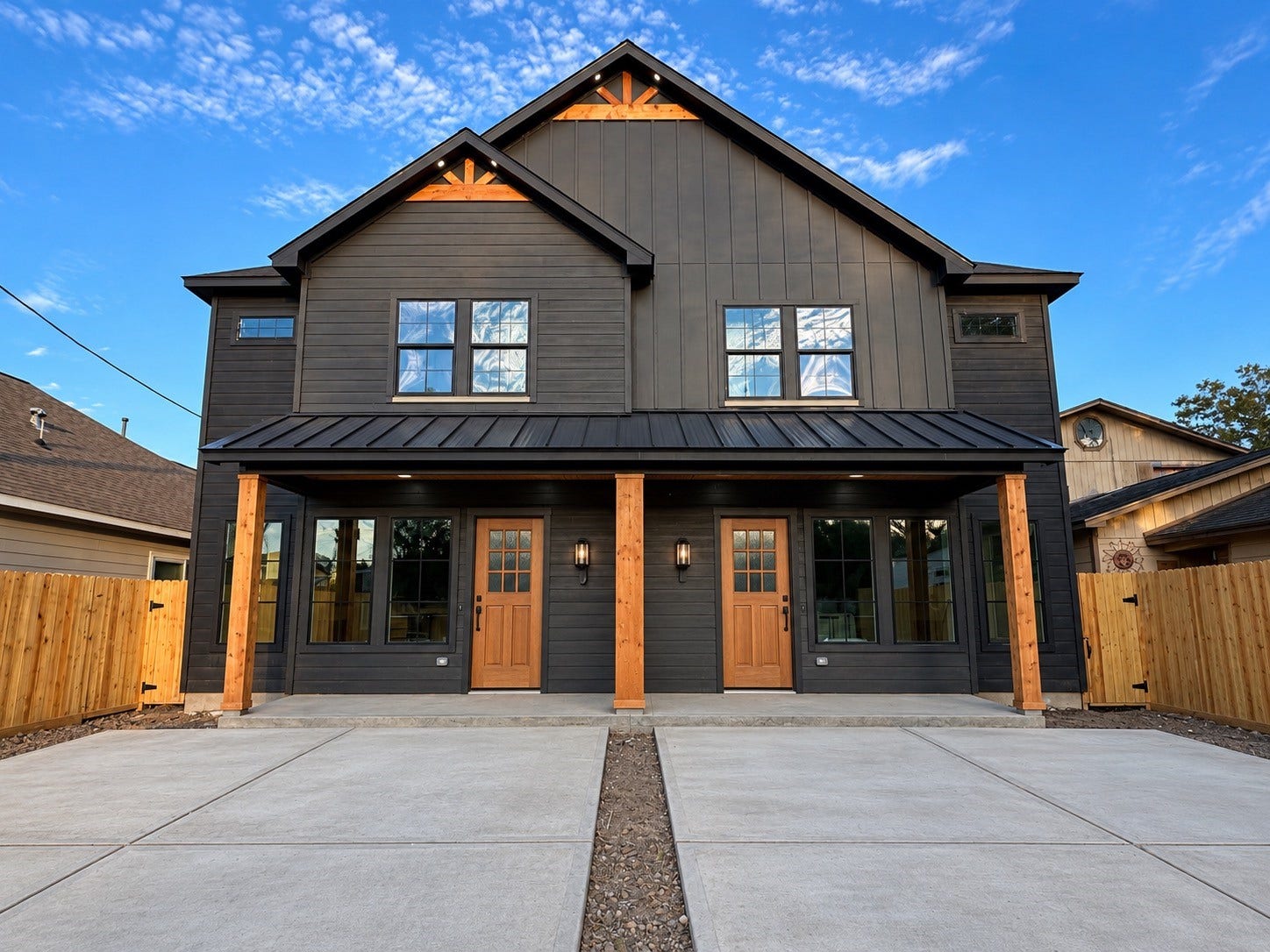 8018 Moon Beam Street, #A/B, Houston, TX 77088 Modern Barn House Duplex with sleek black siding, warm wooden accents, and spacious driveways. This photo has been virtually rendered based on a previous home constructed by the builder.