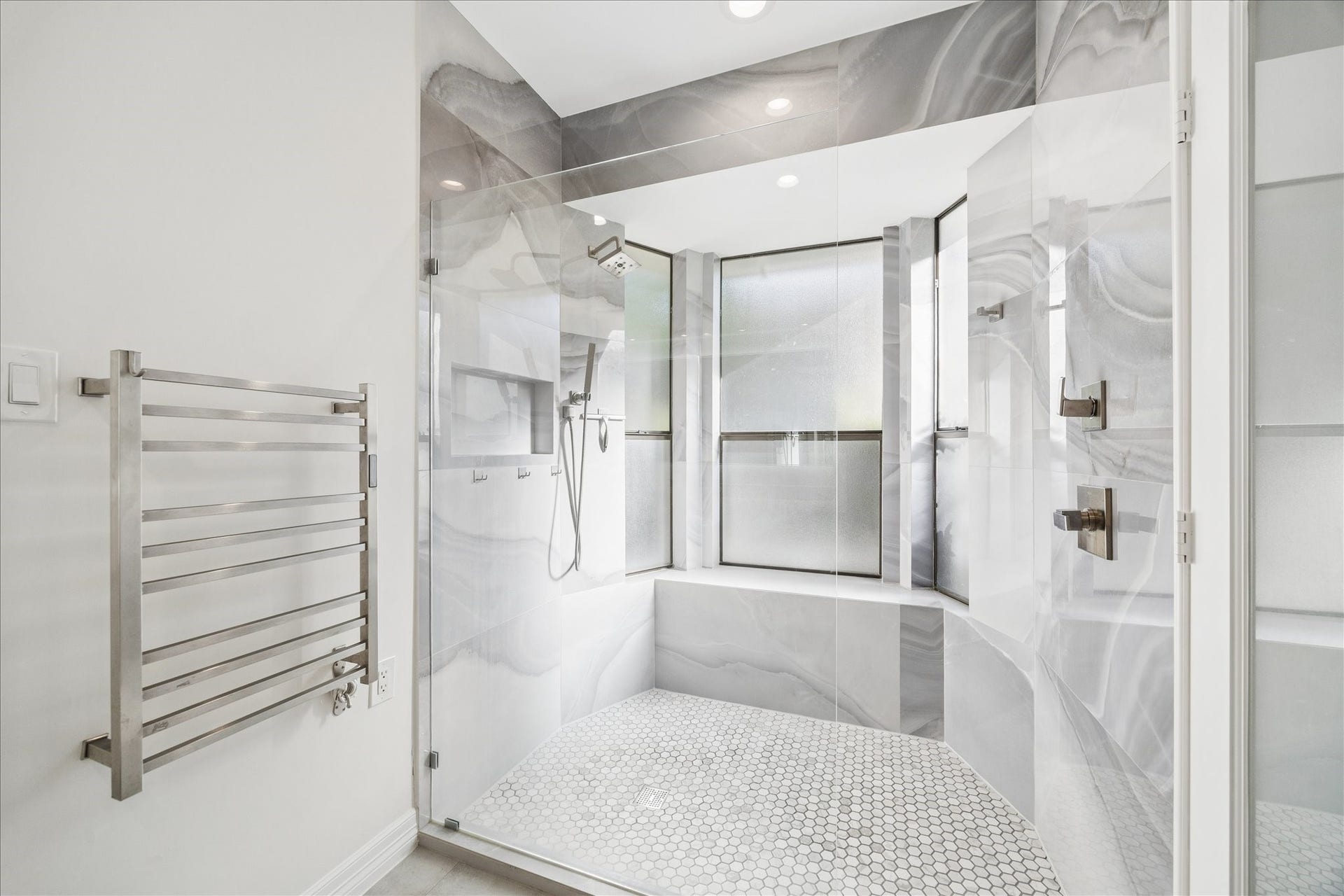 Luxurious primary bath featuring an oversized shower and premium finishes