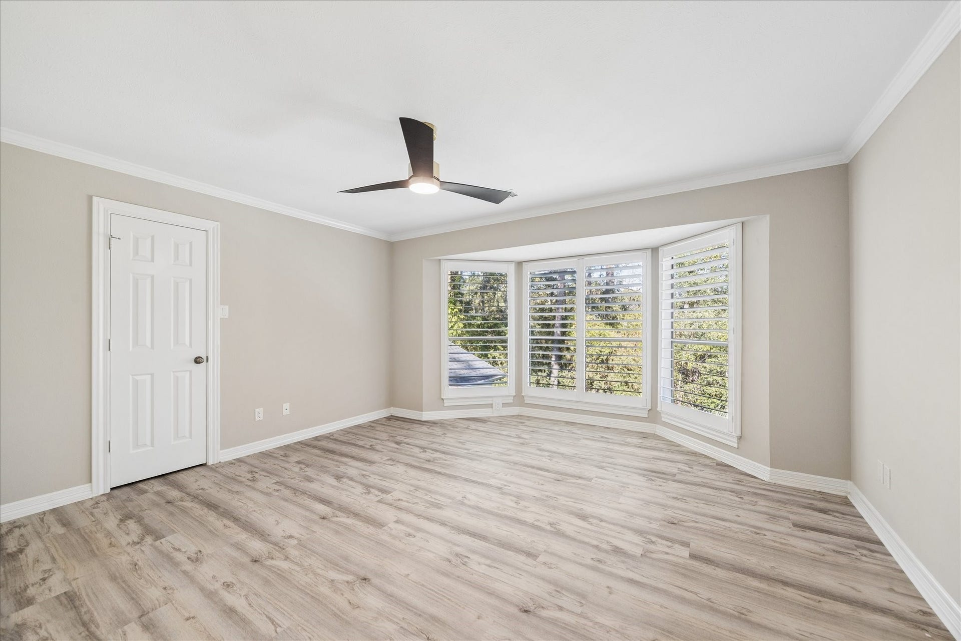 Secondary bedroom  upstairs overlooking the property's mature landscape.