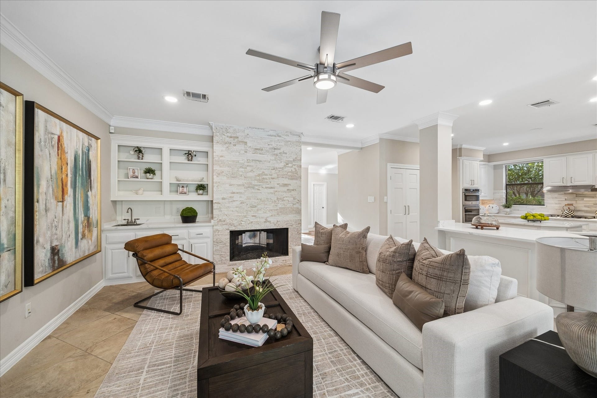 Living area overlooking the kitchen, creating an inviting flow throughout the home. The fireplace delightfully shows the stone enclosure wich makes the room feel elevated.