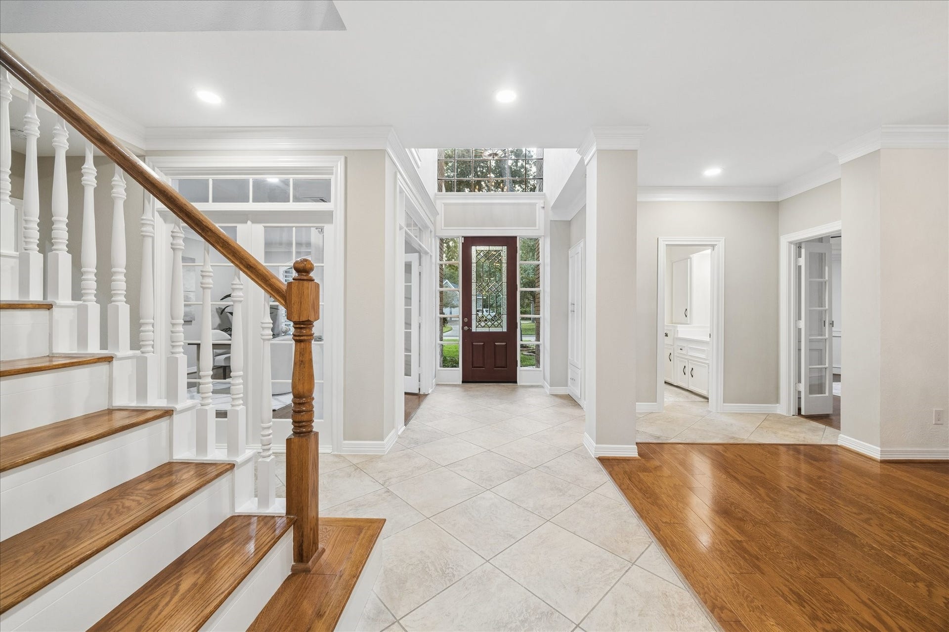 Grand foyer with sweeping staircase and refined architectural details.