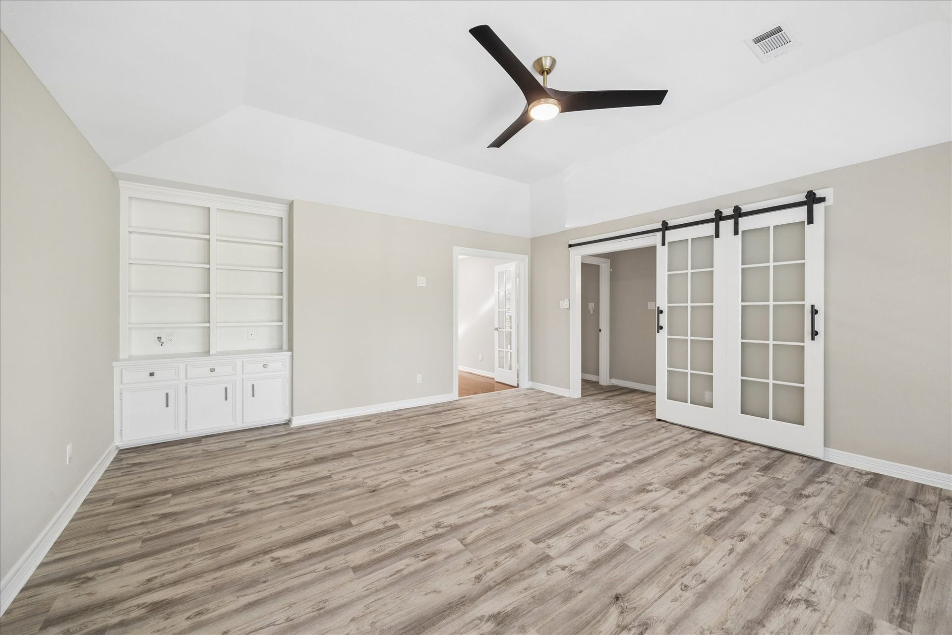 The spacious game room upstairs with custom shelves, exceptional views of the mature landsscape.
